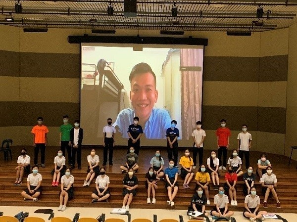 Group photo in school hall with speaker in zoom