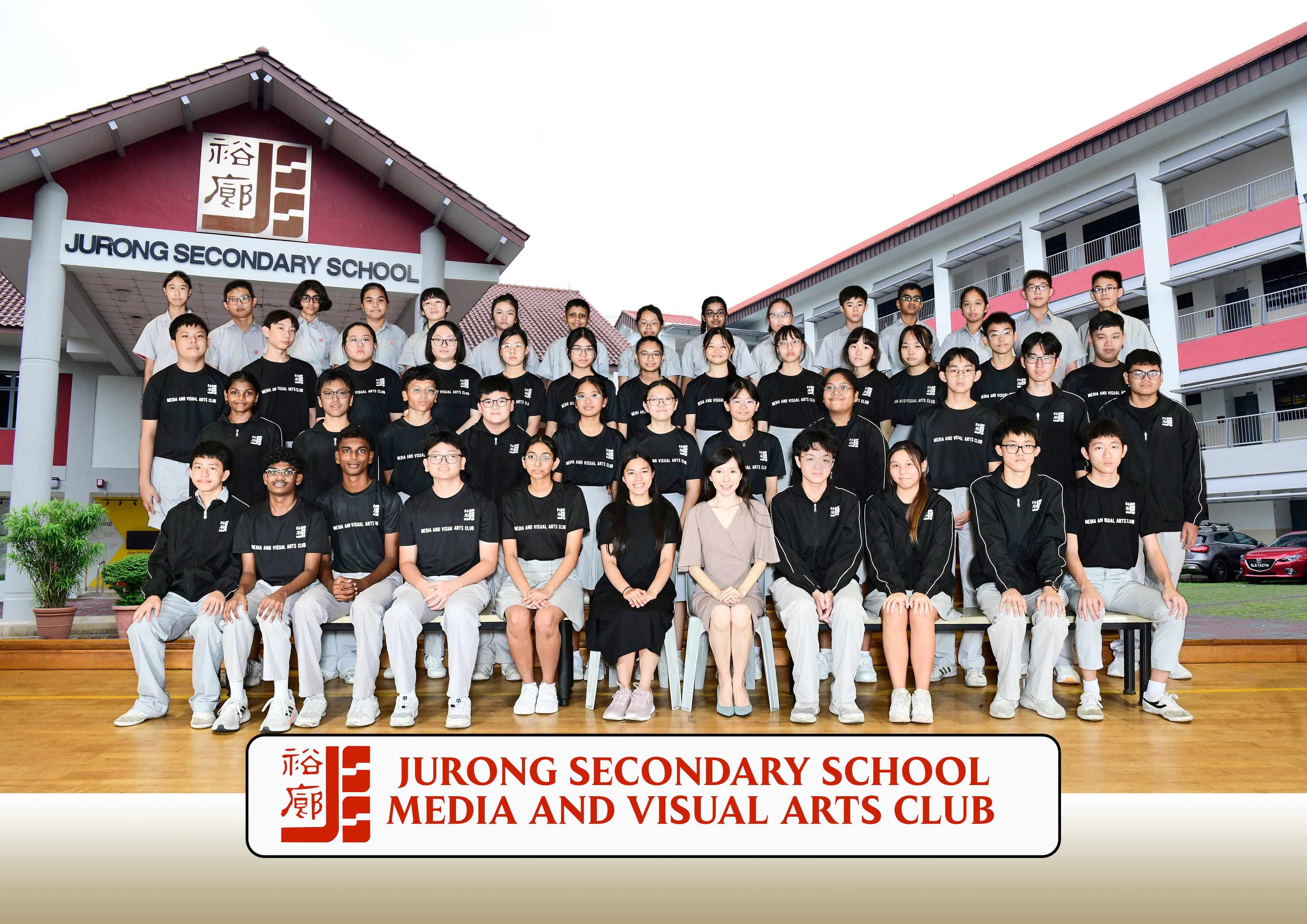 Group photo of Jurong Secondary School Media and Visual Arts Club members posing in front of the school building.