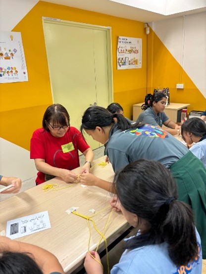 A collaborative and detailed training workshop session where Peer Support Leaders work closely with adult mentors to learn tactile mindfulness techniques, expanding their toolkits for school welfare.