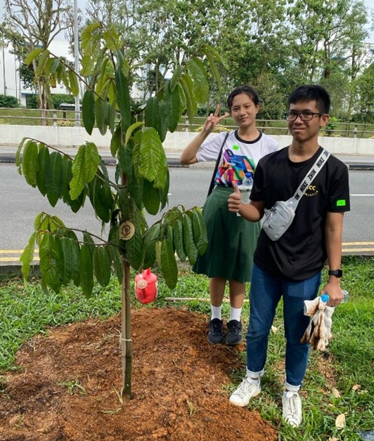 An outdoor community sustainability project or tree-planting ceremony led by Student Leaders, highlighting environmental stewardship and hands-on civic action.🔍 Key Visua