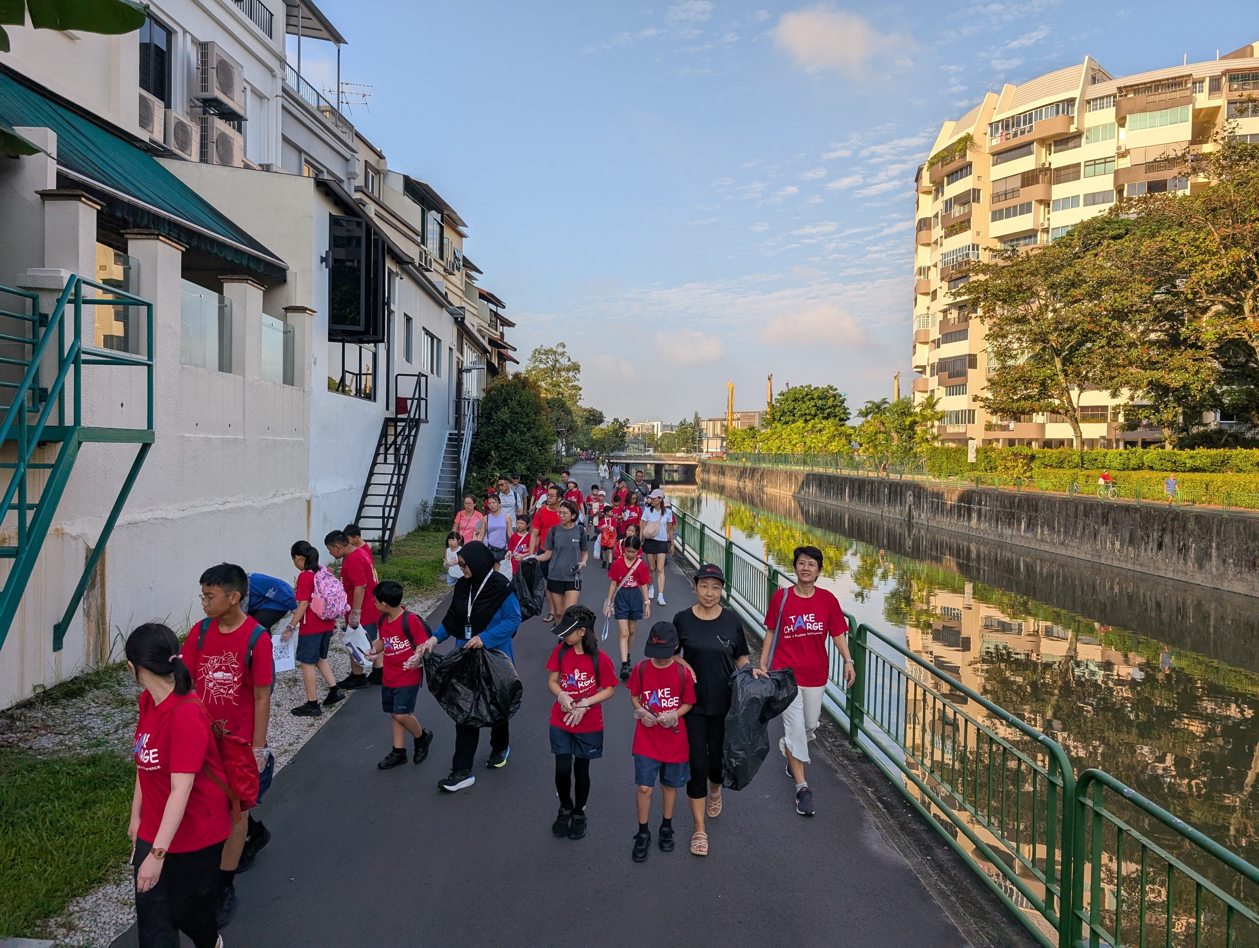 Staff, students and parents walking down Jurong Canal, looking for litter to pick up