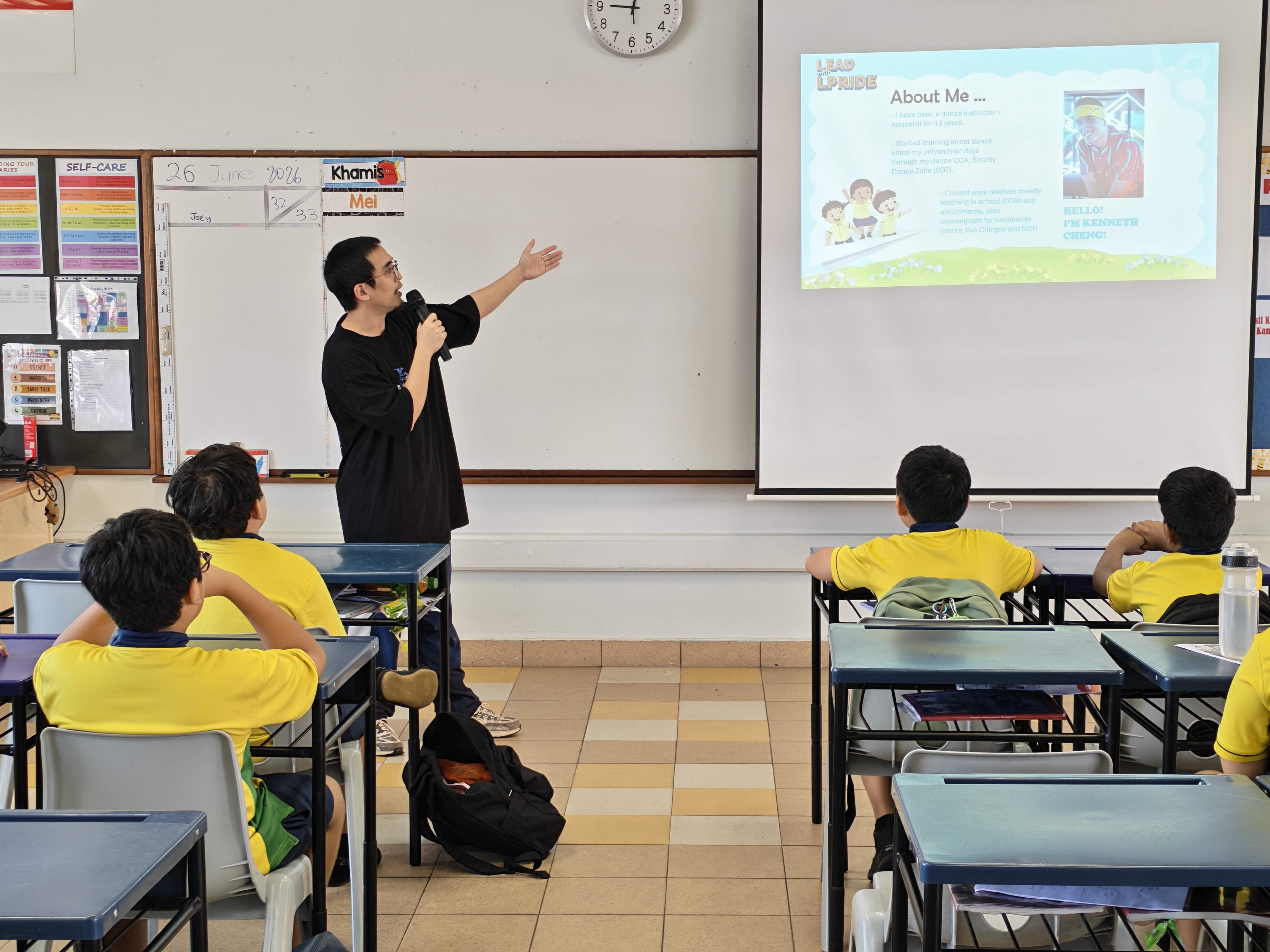 A Dance Instructor presents his career journey to Primary 6 students using presentation slides while students listen attentively.