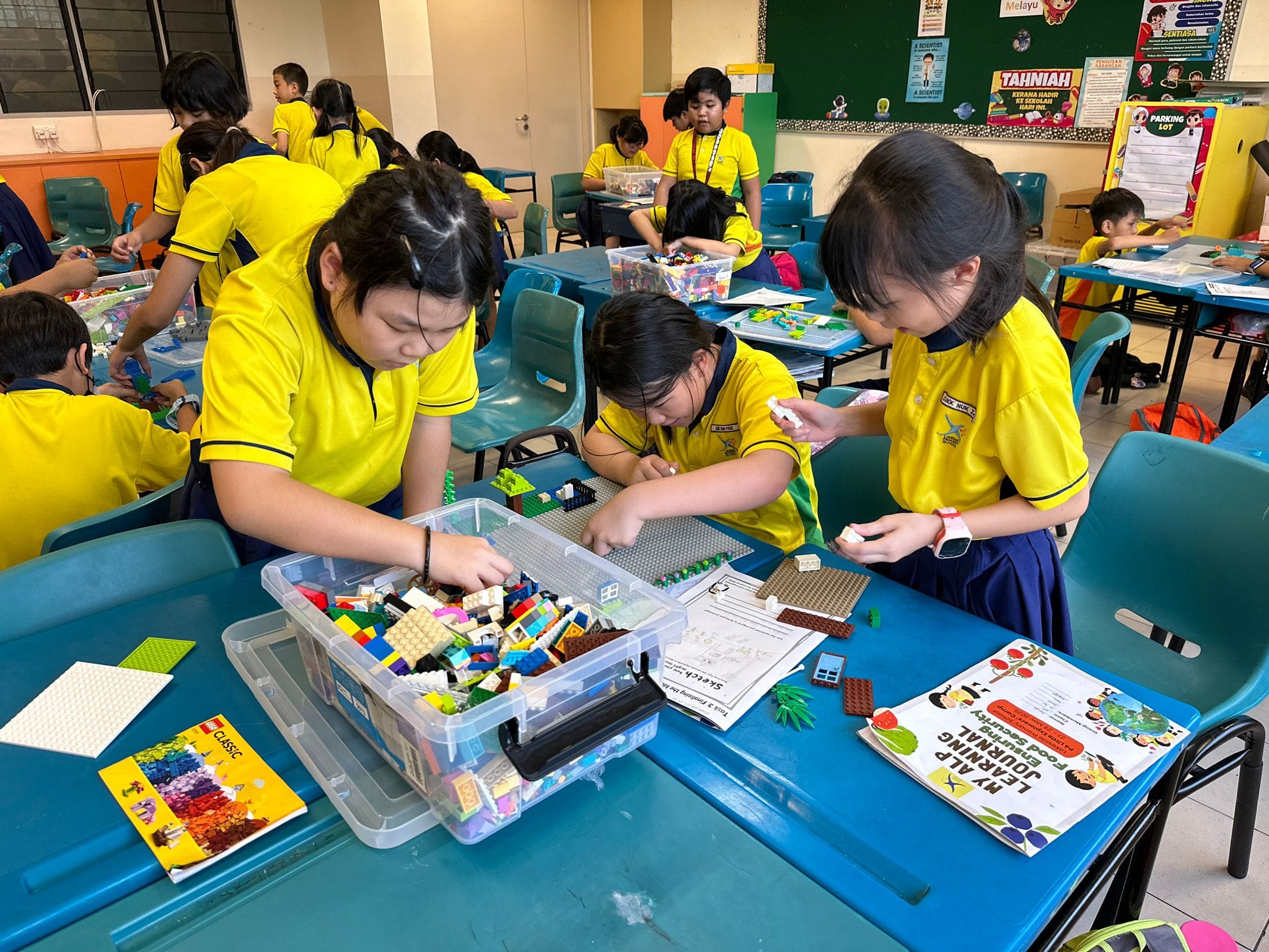 Three students work together to assemble LEGO bricks as part of a hands-on building activity.