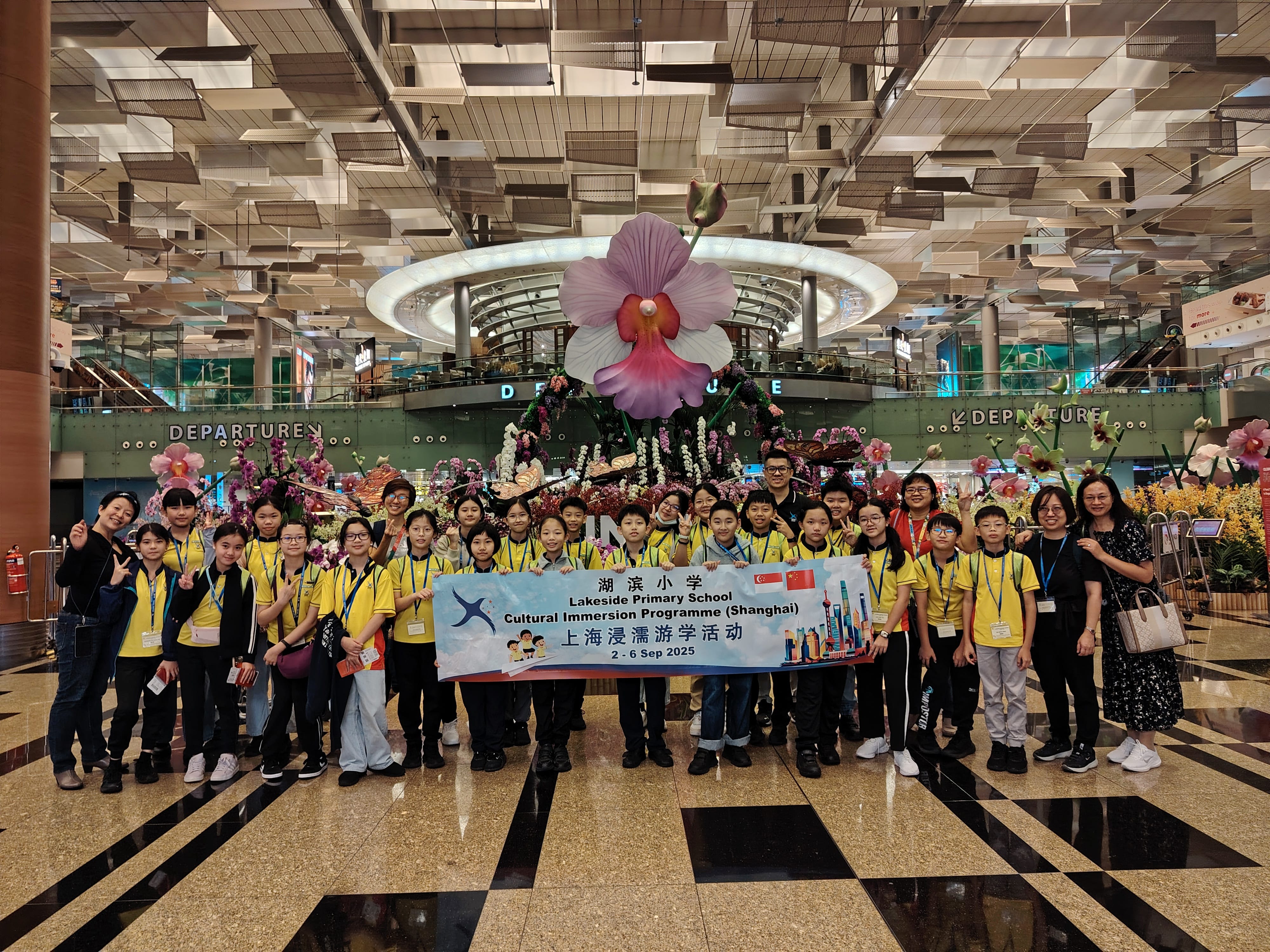 Filled with excitement, the students were ready to set off on their journey as they take a group photo at the airport with their teachers