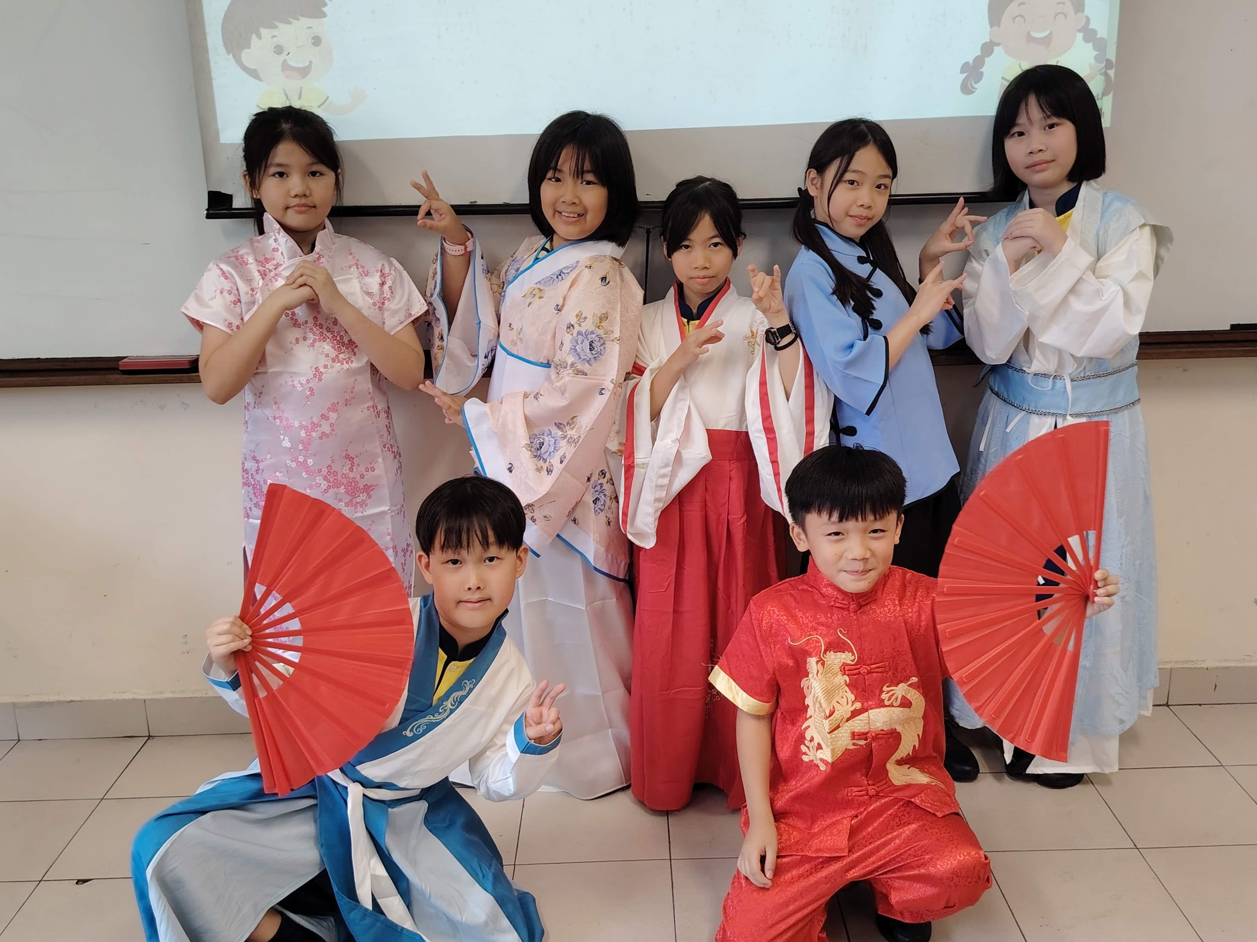 A group of P4 students posing for a group photo as they are dressed in various traditional costumes of different dynasties in ancient China
