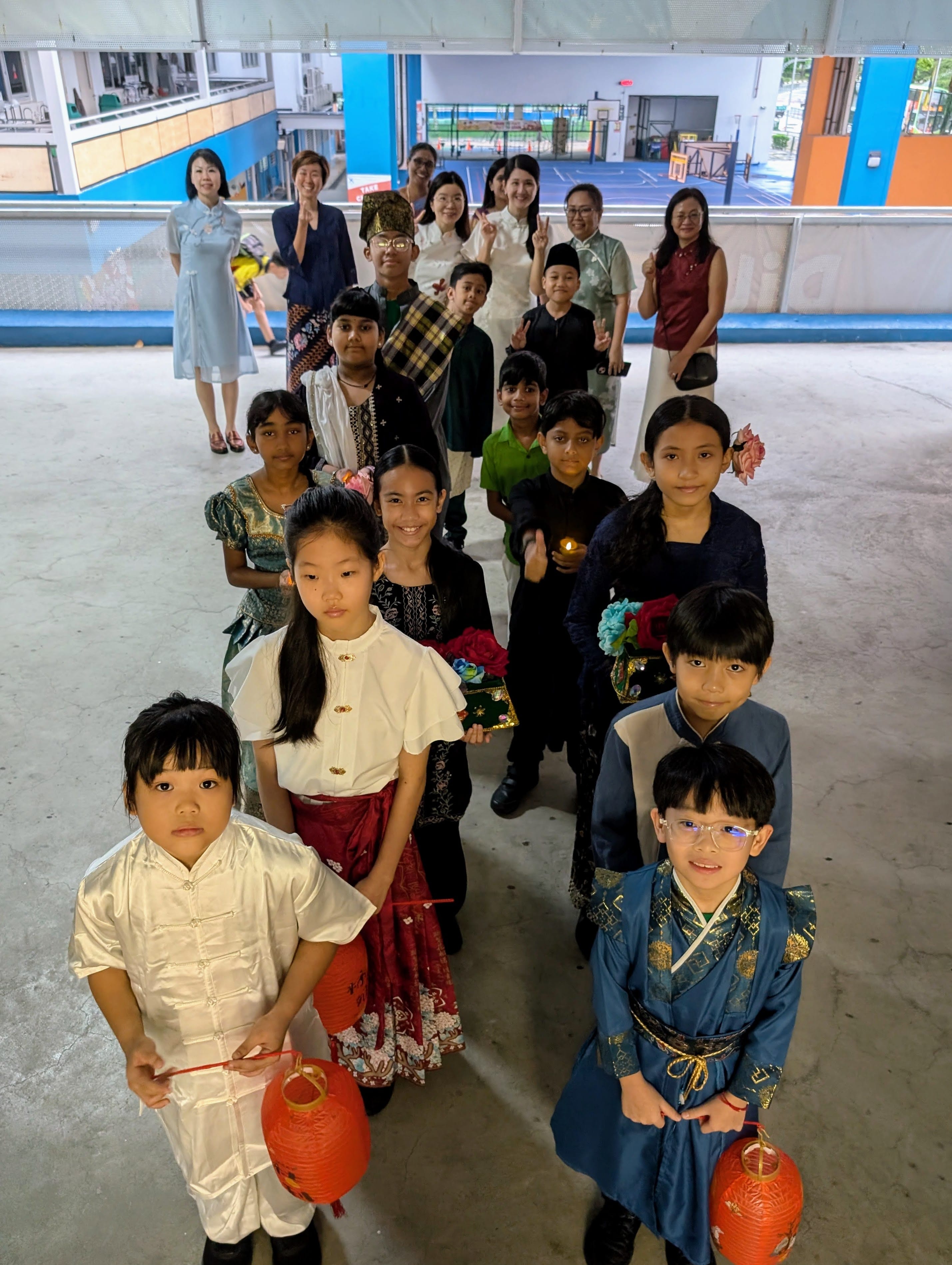Students and teachers in traditional multicultural costumes ready to march into the hall
