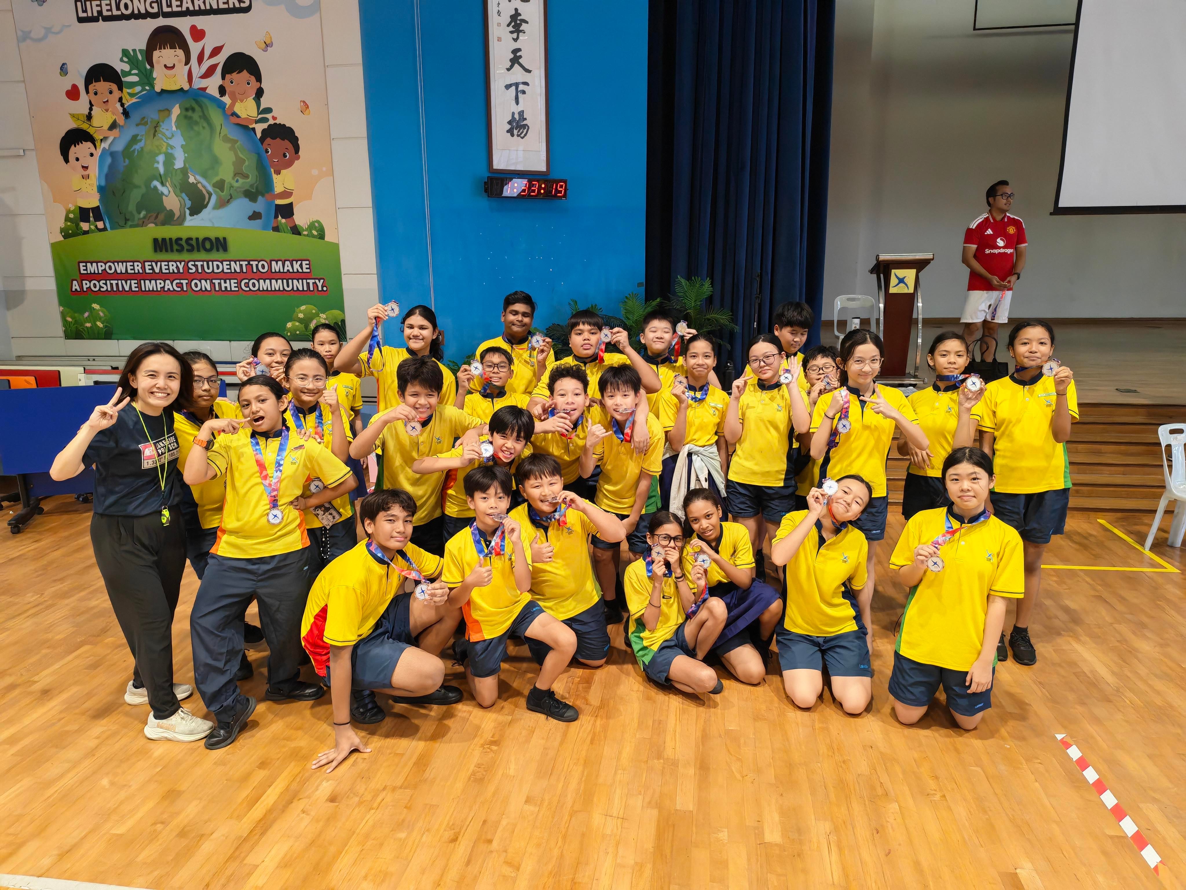 The class that clinched the runner-up position, P6 Love, poses for a group photo with their medals and their teacher