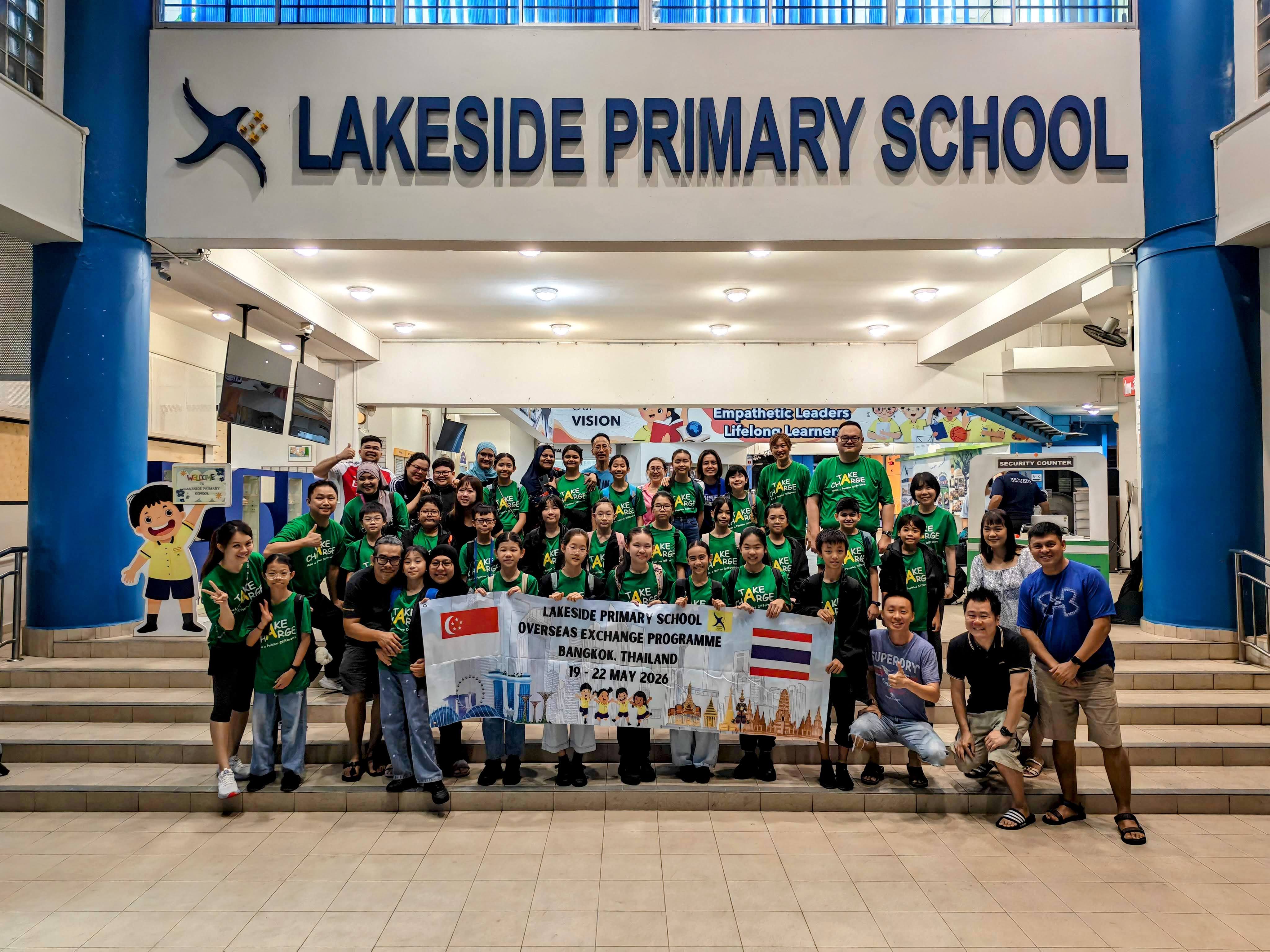 Students from Lakeside Primary take a group photo in front of the school with their teachers and parents