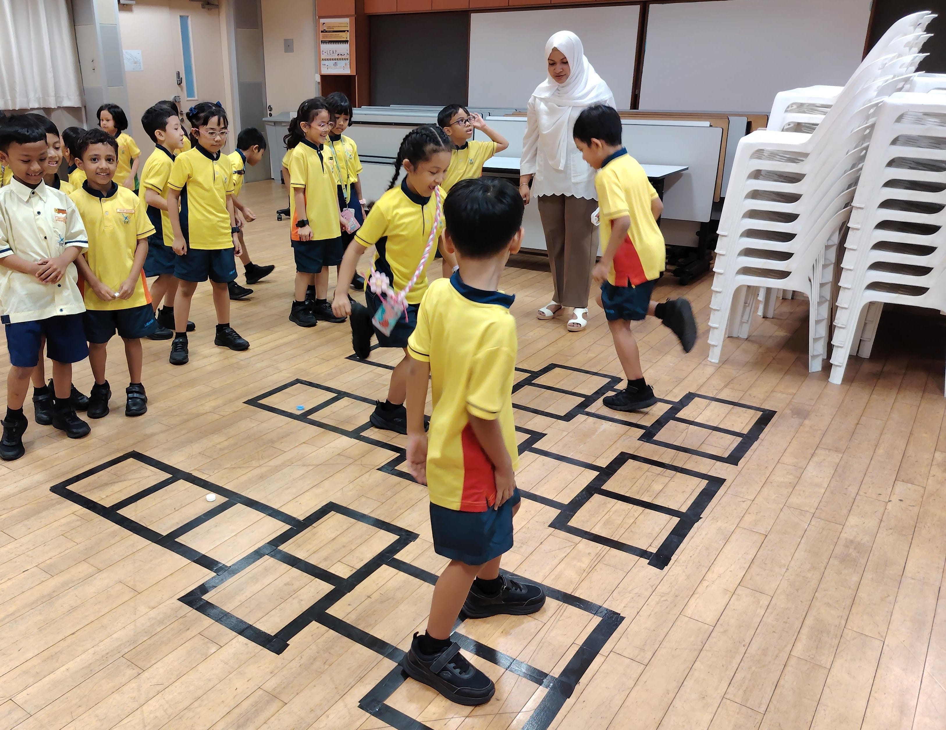 Primary 1 students queued for their turn and hopped into fun with a lively game of tingting (hopscotch)