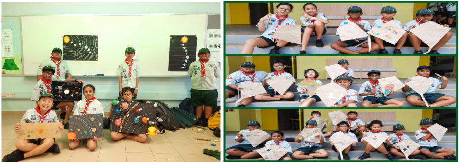 Young scouts in uniform display handmade solar system projects and kite drawings in a classroom and on steps.