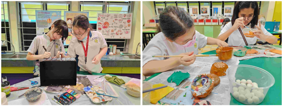 Two students paint on a black canvas while two others paint decorative objects at a craft table.