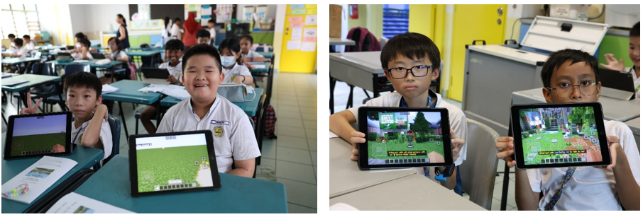 Young students in a classroom hold up tablets showing a Minecraft game, smiling at the camera.