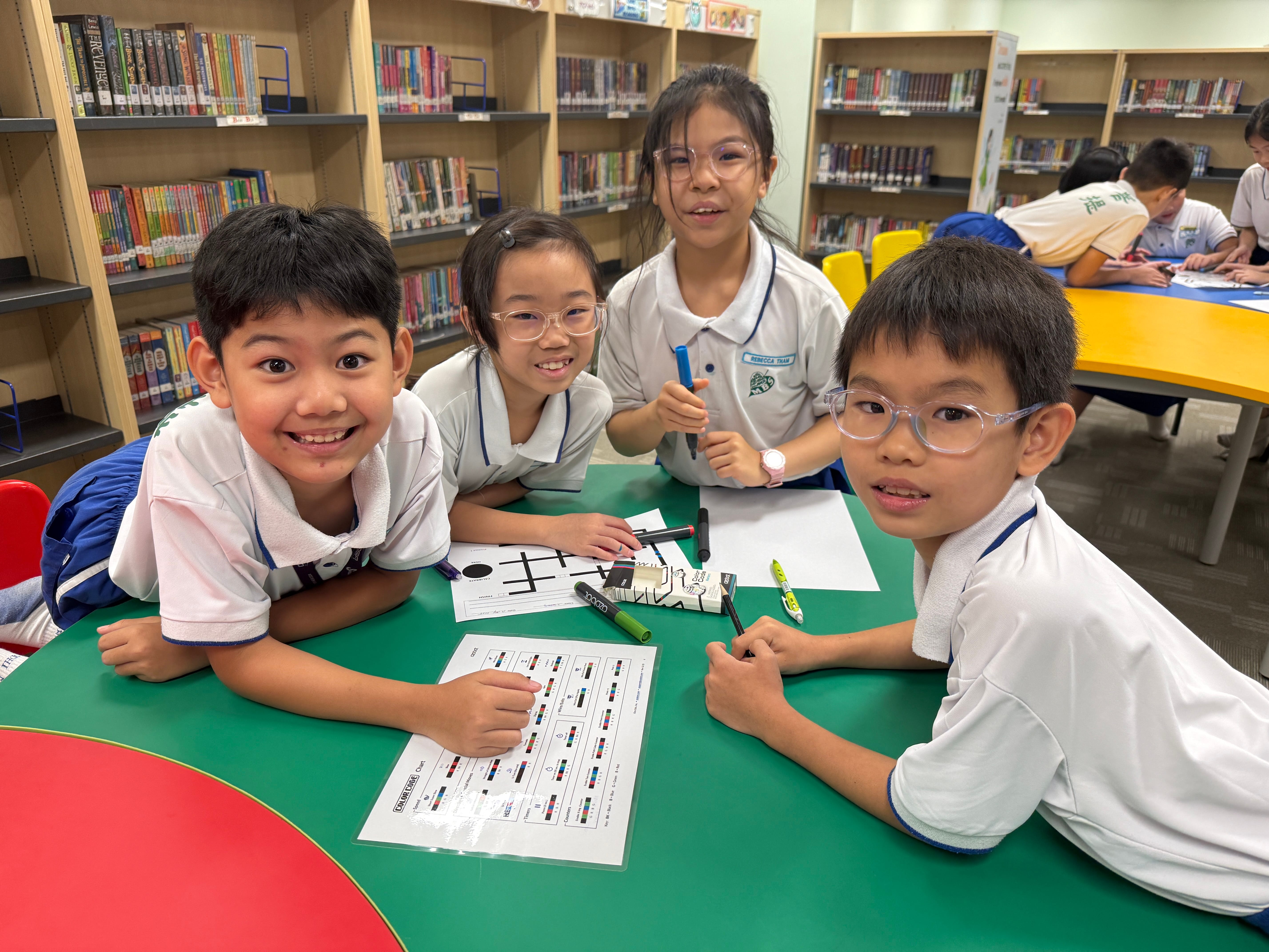 Primary 3 students experiencing Ozobot session in school library.