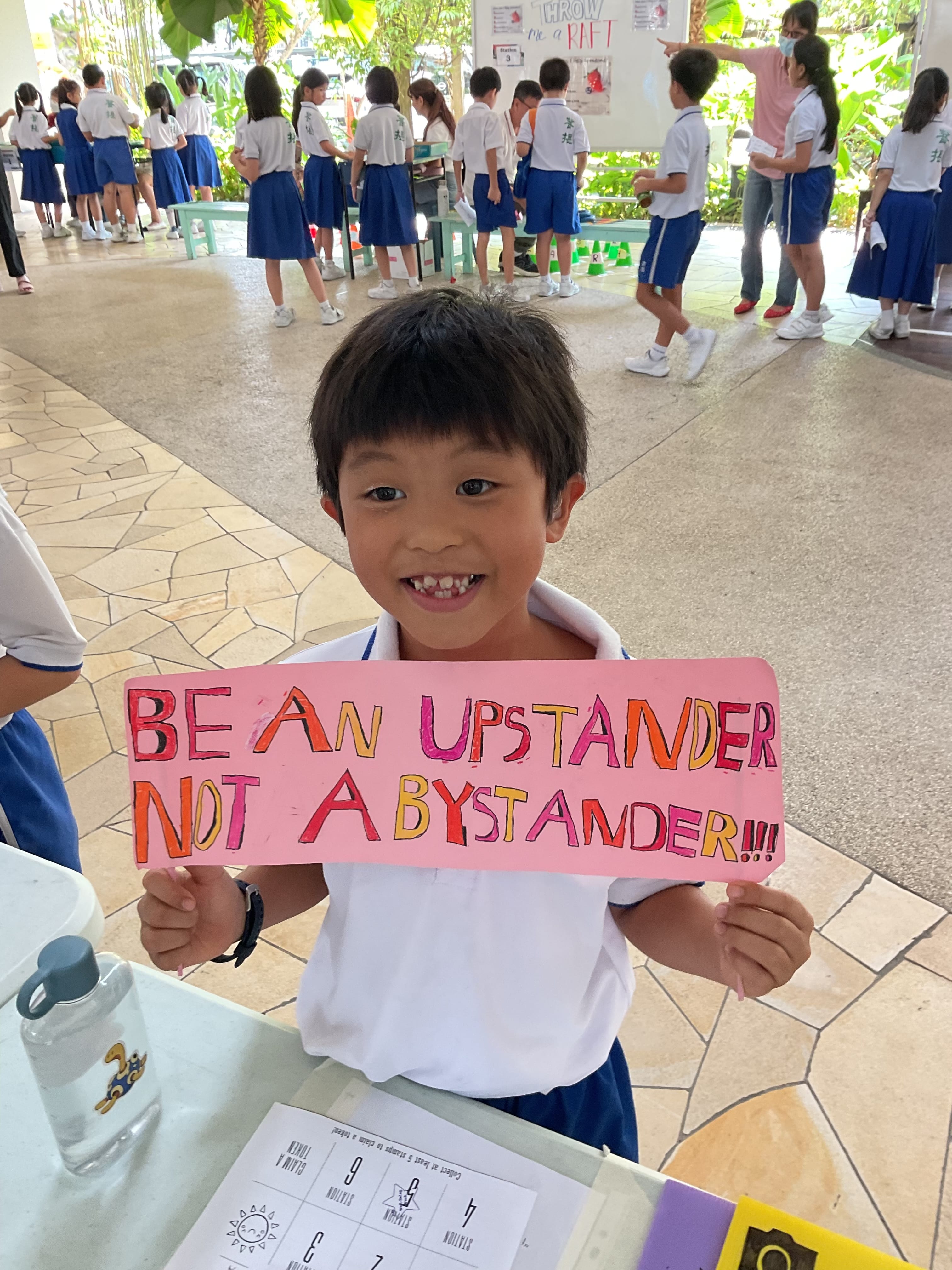Young boy displaying a banner written 'Be a upstander not a bystander'