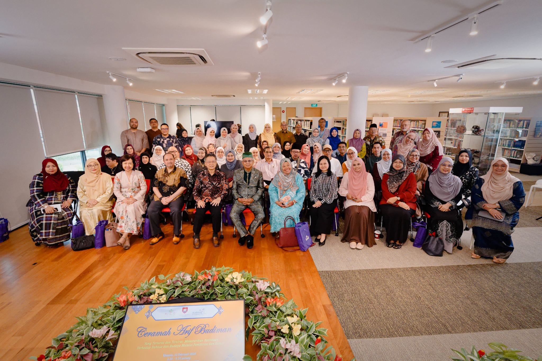 Large group of formally dressed people posing for a photo indoors at a Ceramah Arif Budiman event.