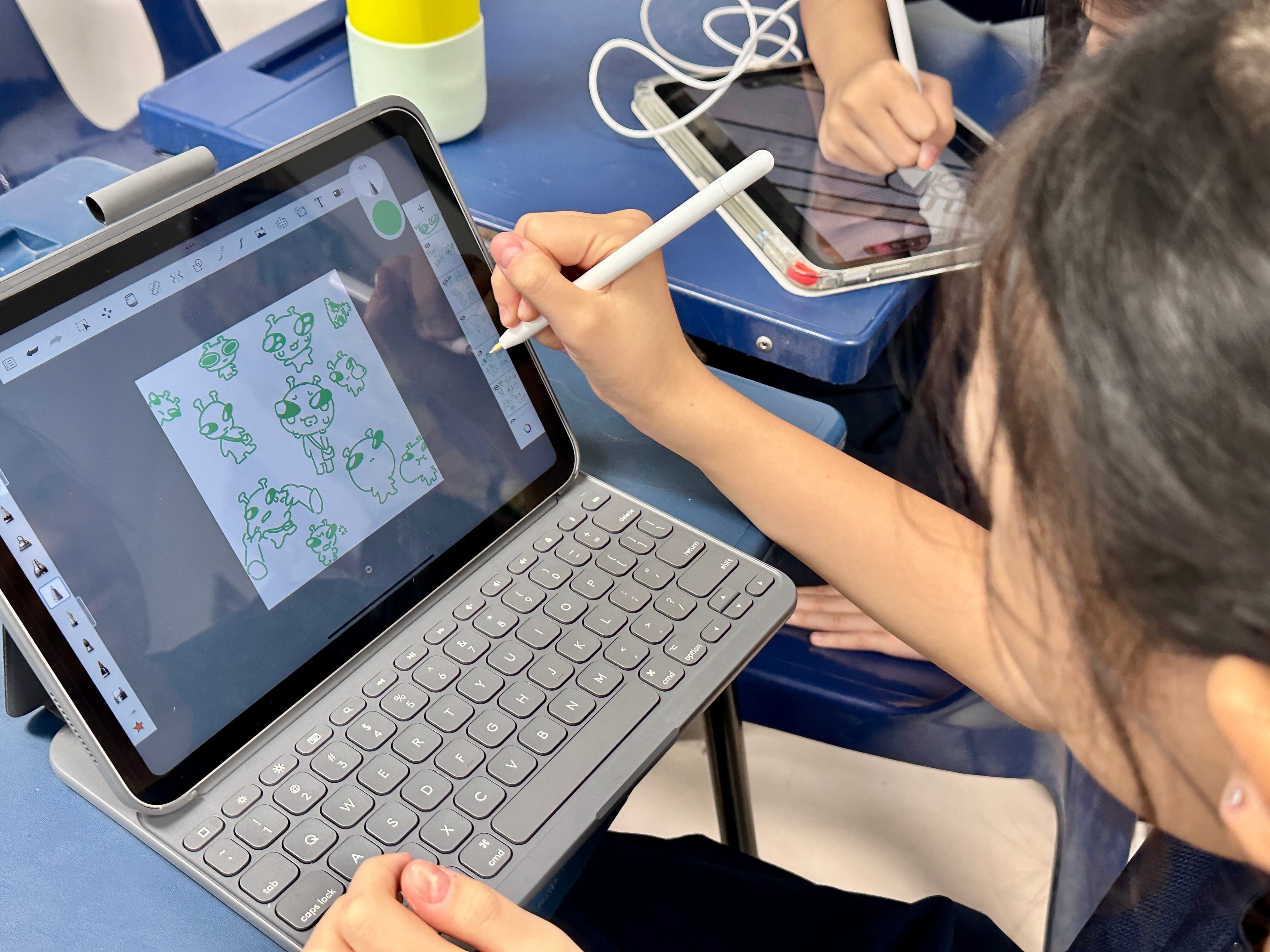 A child draws cartoon characters on a tablet with a stylus, using a drawing app showing green sketches.