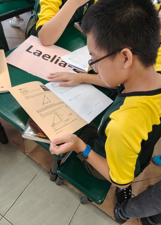 A top down view of a male student looking at a trigonometric question.
