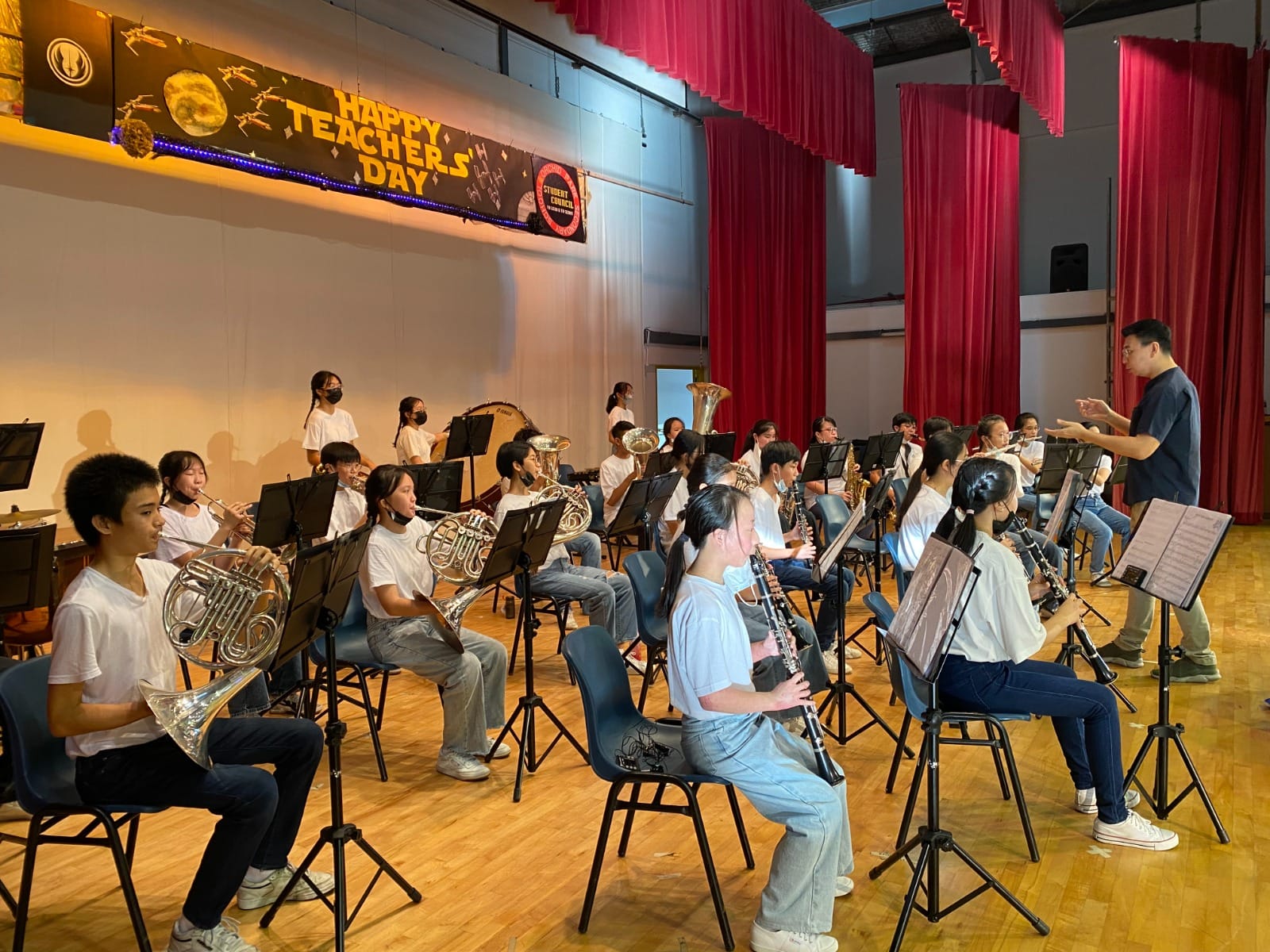 Concert band on stage rehearsing for teachers day