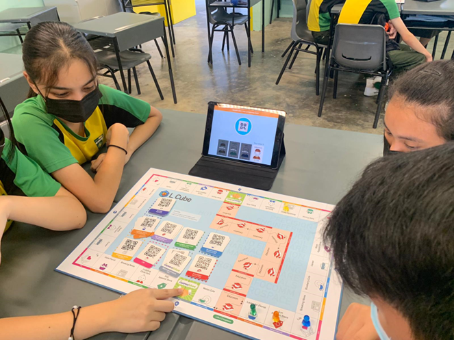 A group of students figuring out the financial literacy board game