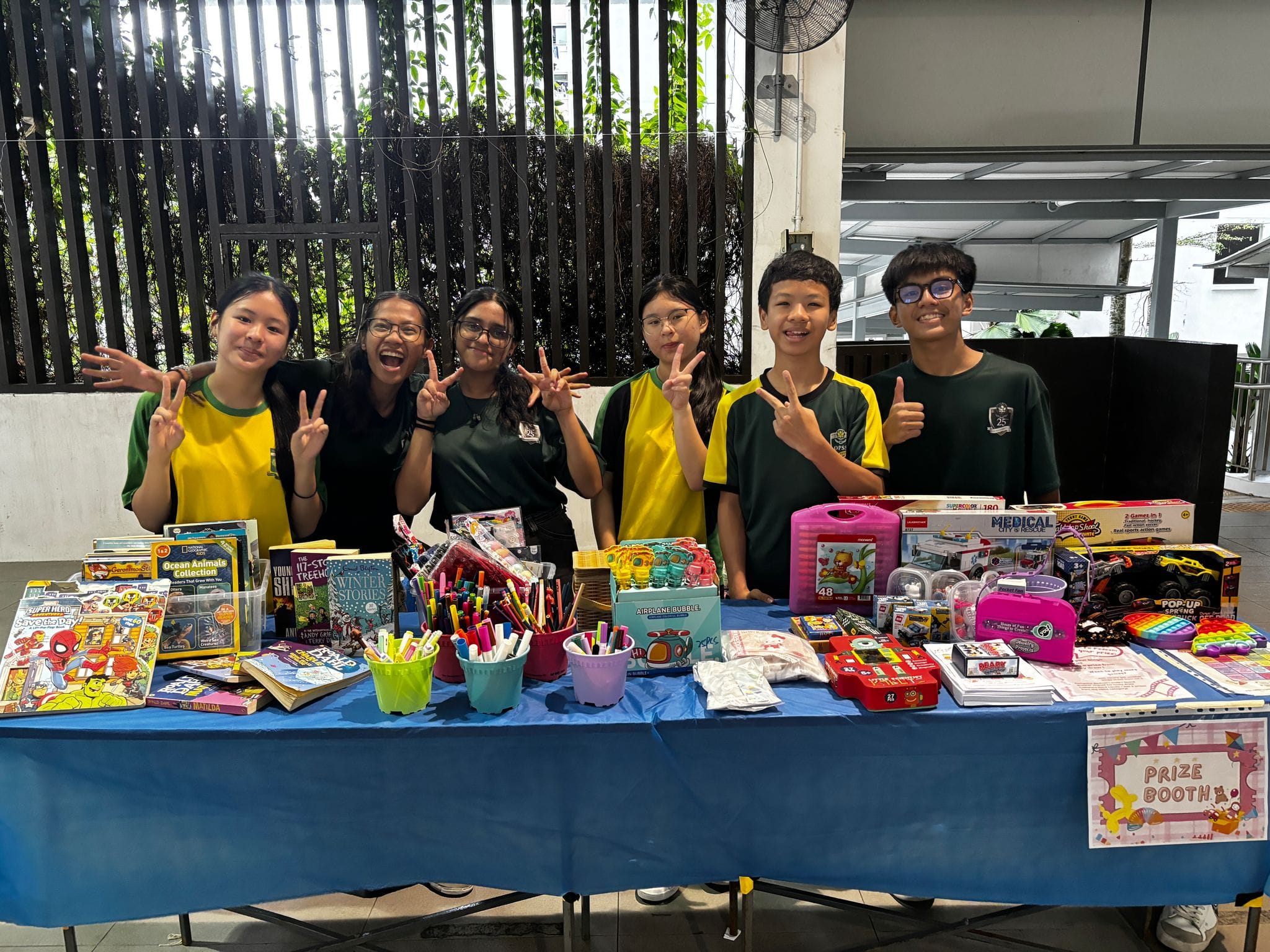 A group of six students posing behind their booth at the HOPE in Every Heart Mini-Funfair