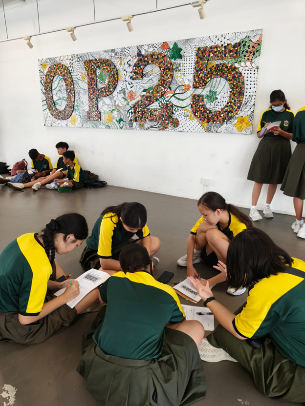 Groups of students seated on the floor working out a mathematics puzzle.