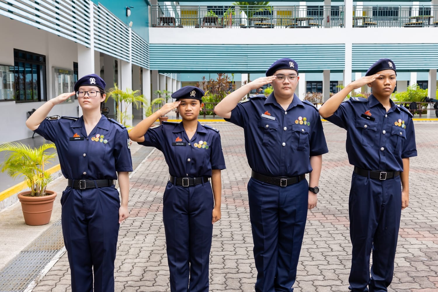 4 students in npcc uniform saluting