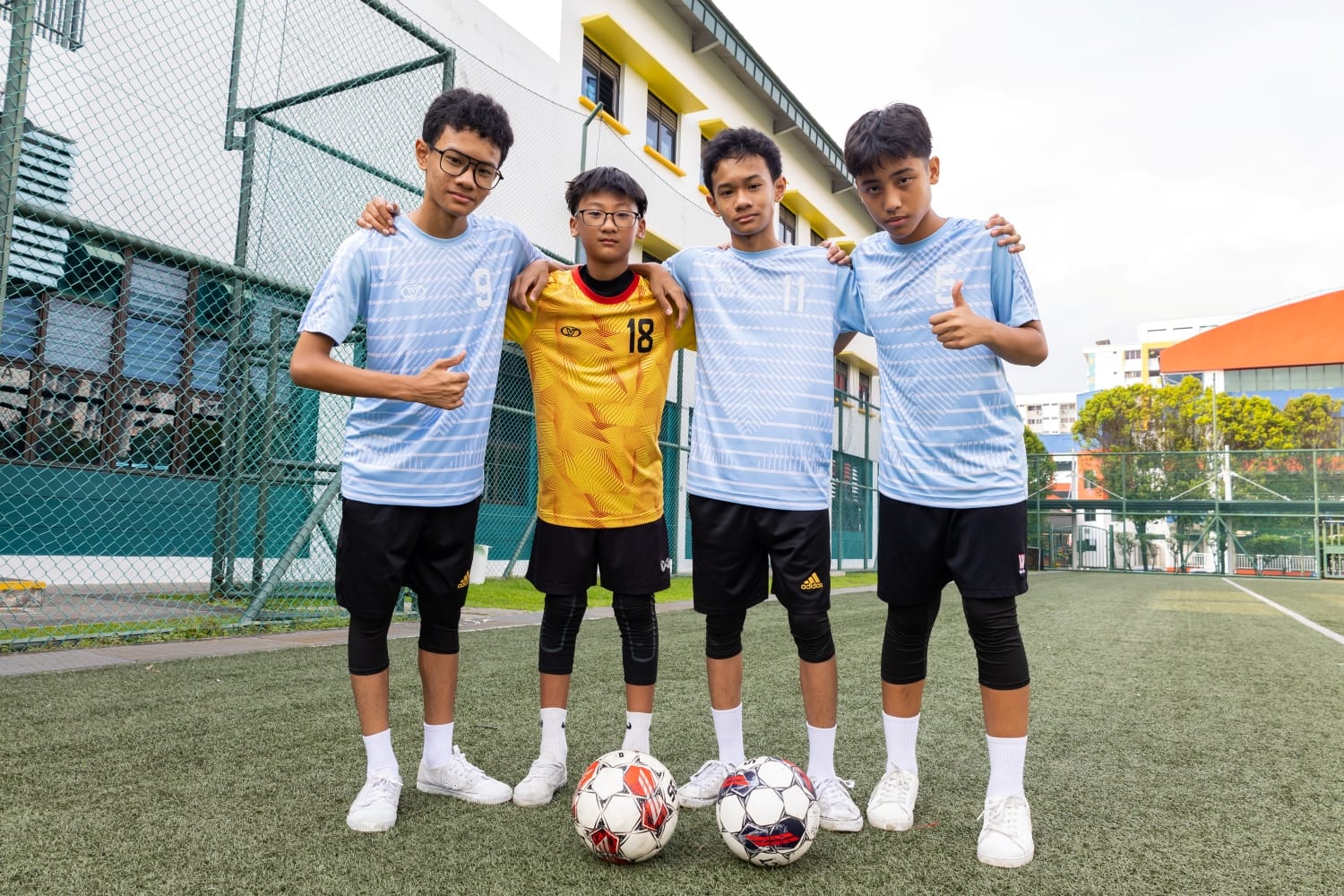 Four football boys posing for a shot on the football field.