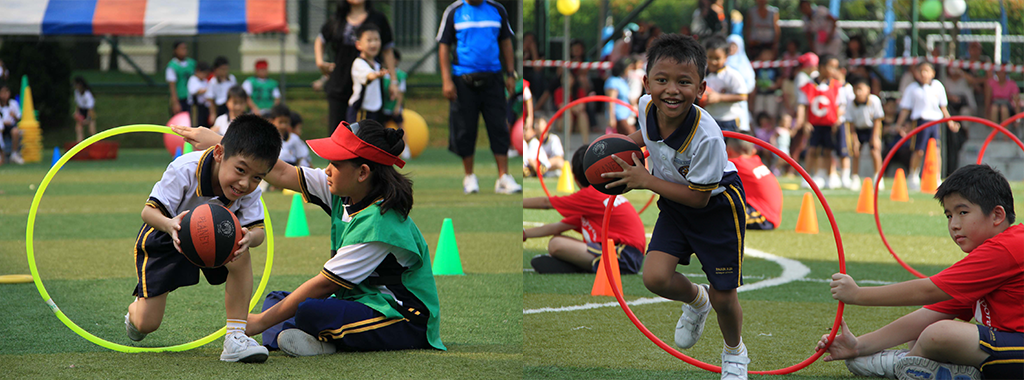 Children playing a sports activity on a field, passing basketballs through large colorful hoops held by teammates.