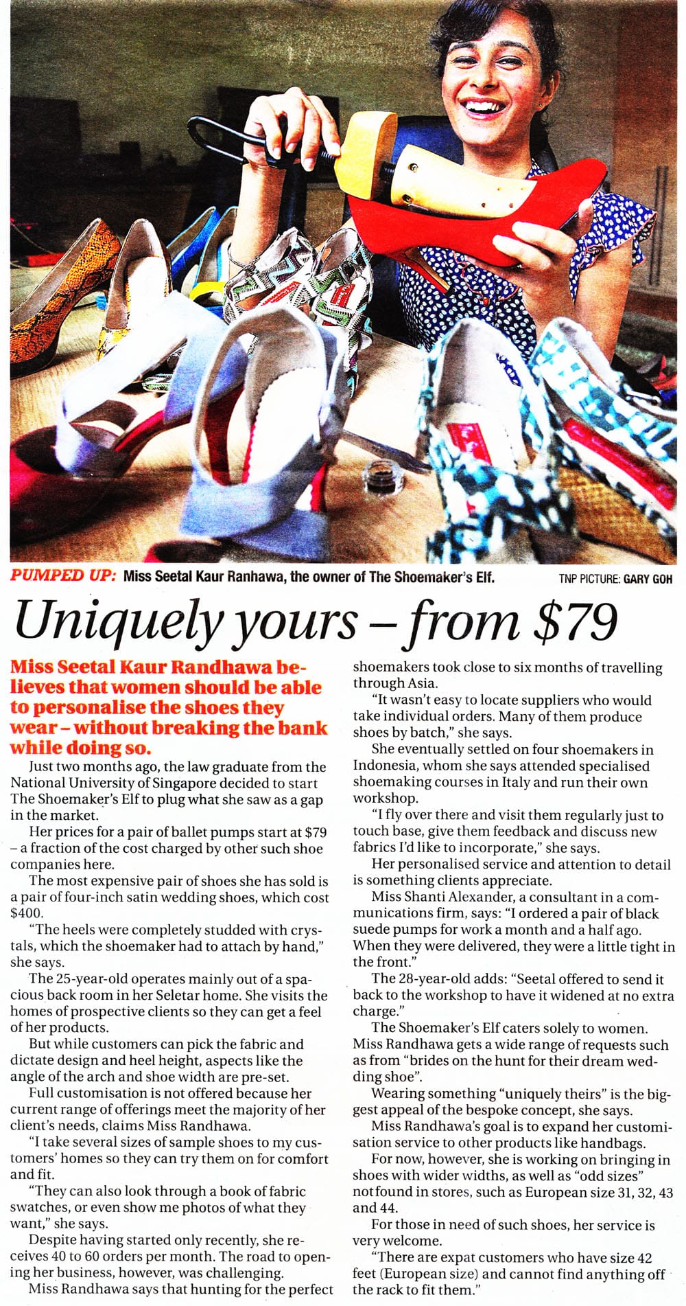 Smiling woman holding a red shoe mold surrounded by colorful heels, above a newspaper article about custom shoes.