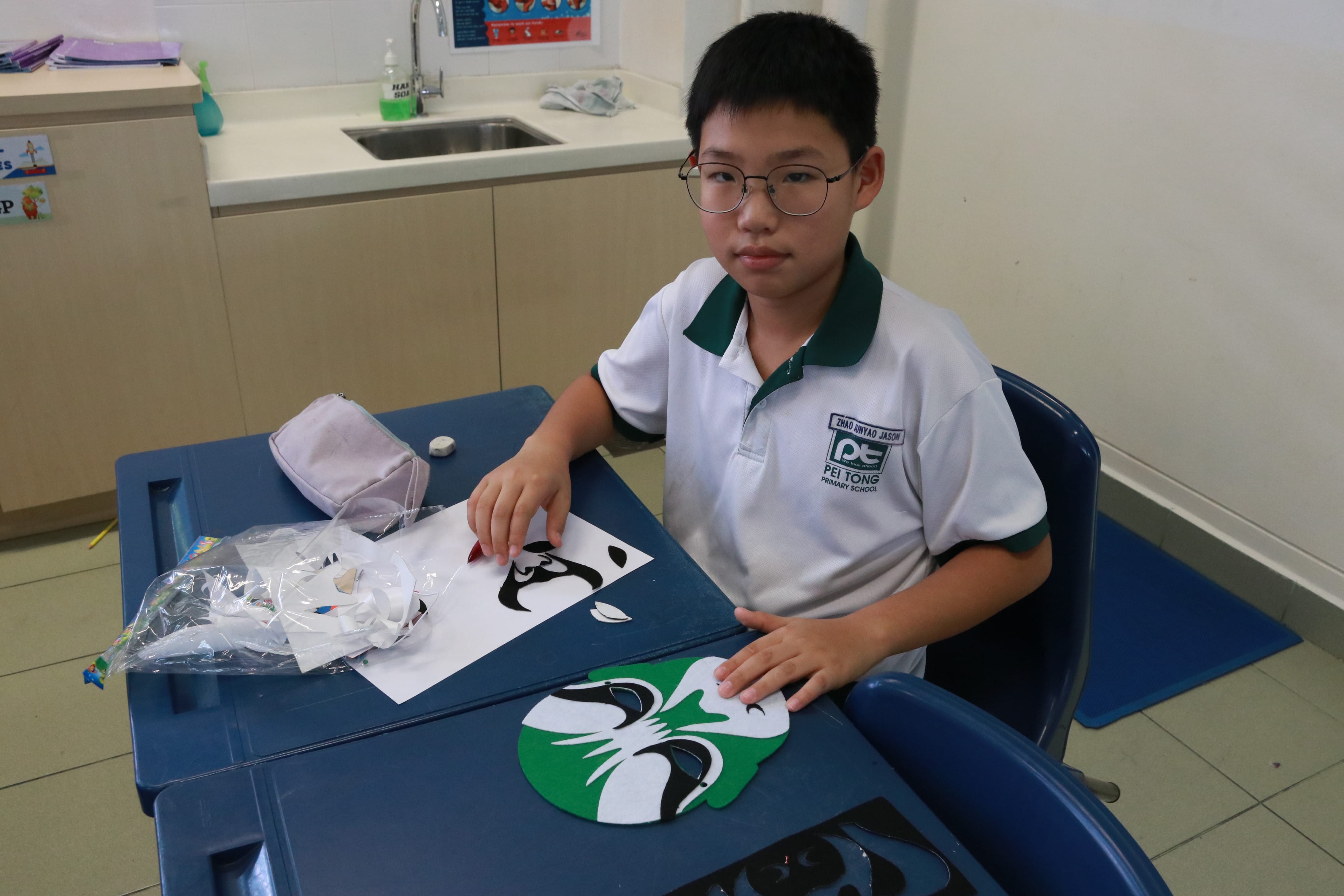 Student posing with a completed traditional opera mask