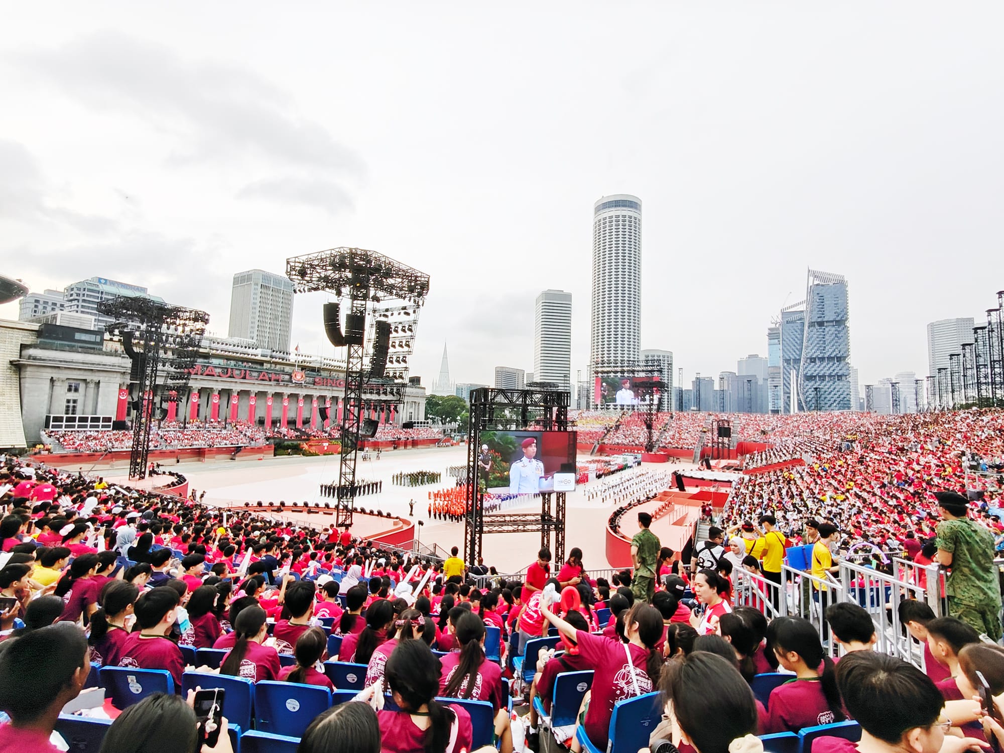 Primary 5 students watch the National Education Show parade and performances, experiencing Singapore's National Day celebrations firsthand.