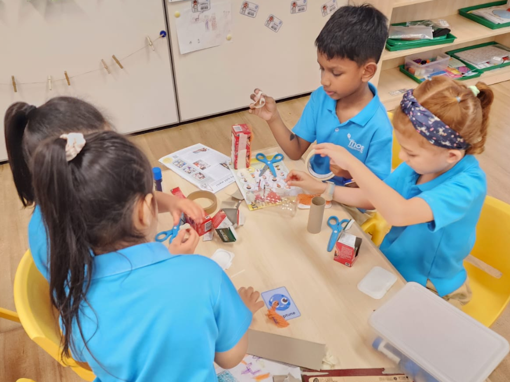 Children use recycled materials to design and build creative projects, fostering imagination, communication and collaborative learning through hands-on exploration.