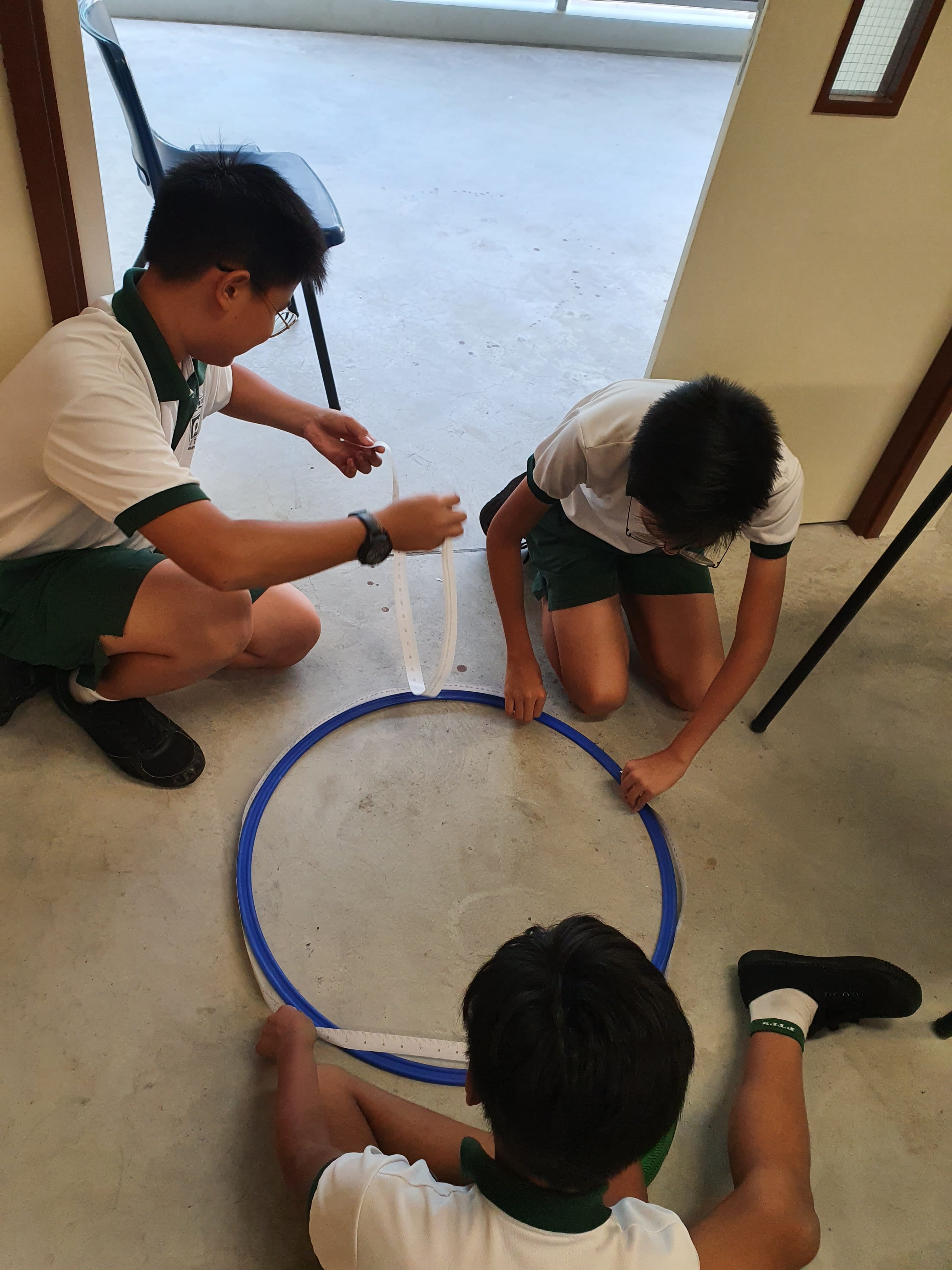 students using hands-on manipulatives during a collaborative mathematics activity, as they work together to explore concepts and communicate their problem-solving ideas through discussion and shared reasoning.