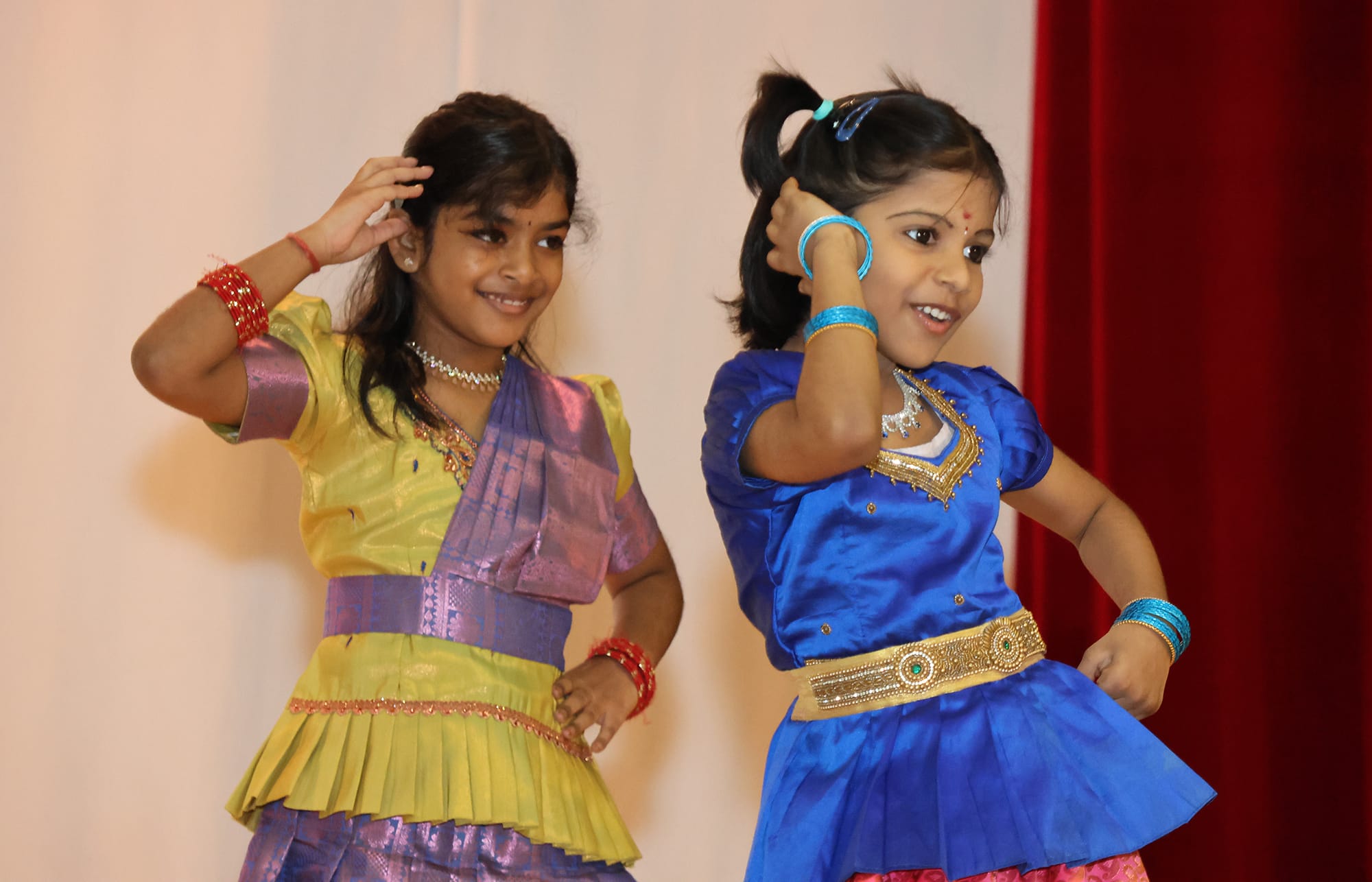 Two young students dressed in colourful traditional Indian costumes perform a dance during the Deepavali celebration.
