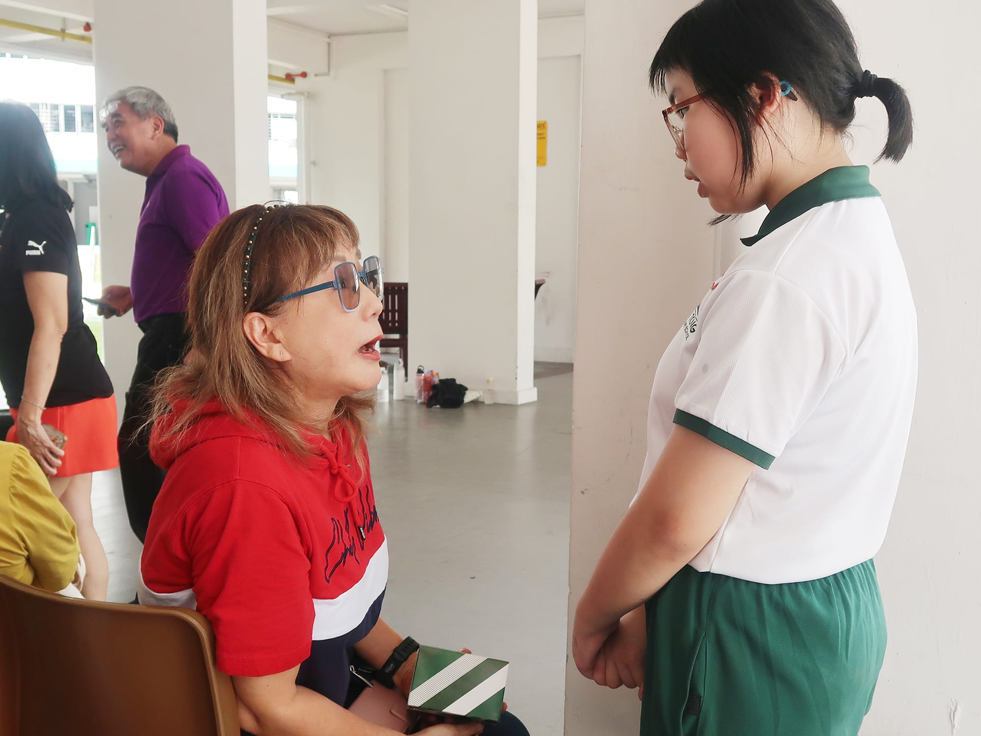 A student chats with a senior, listening attentively and building connections through friendly conversation.