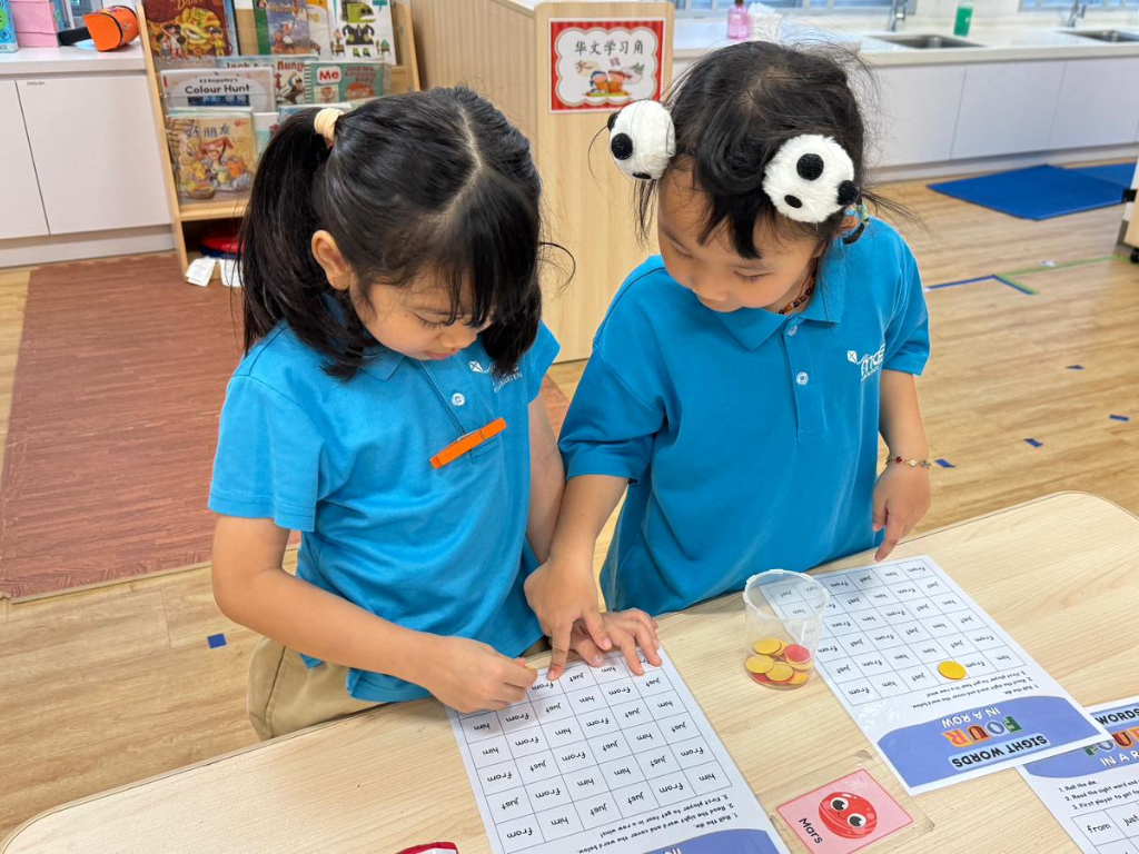 Two children play a sight word matching game together, developing reading fluency, vocabulary and cooperative learning skills.