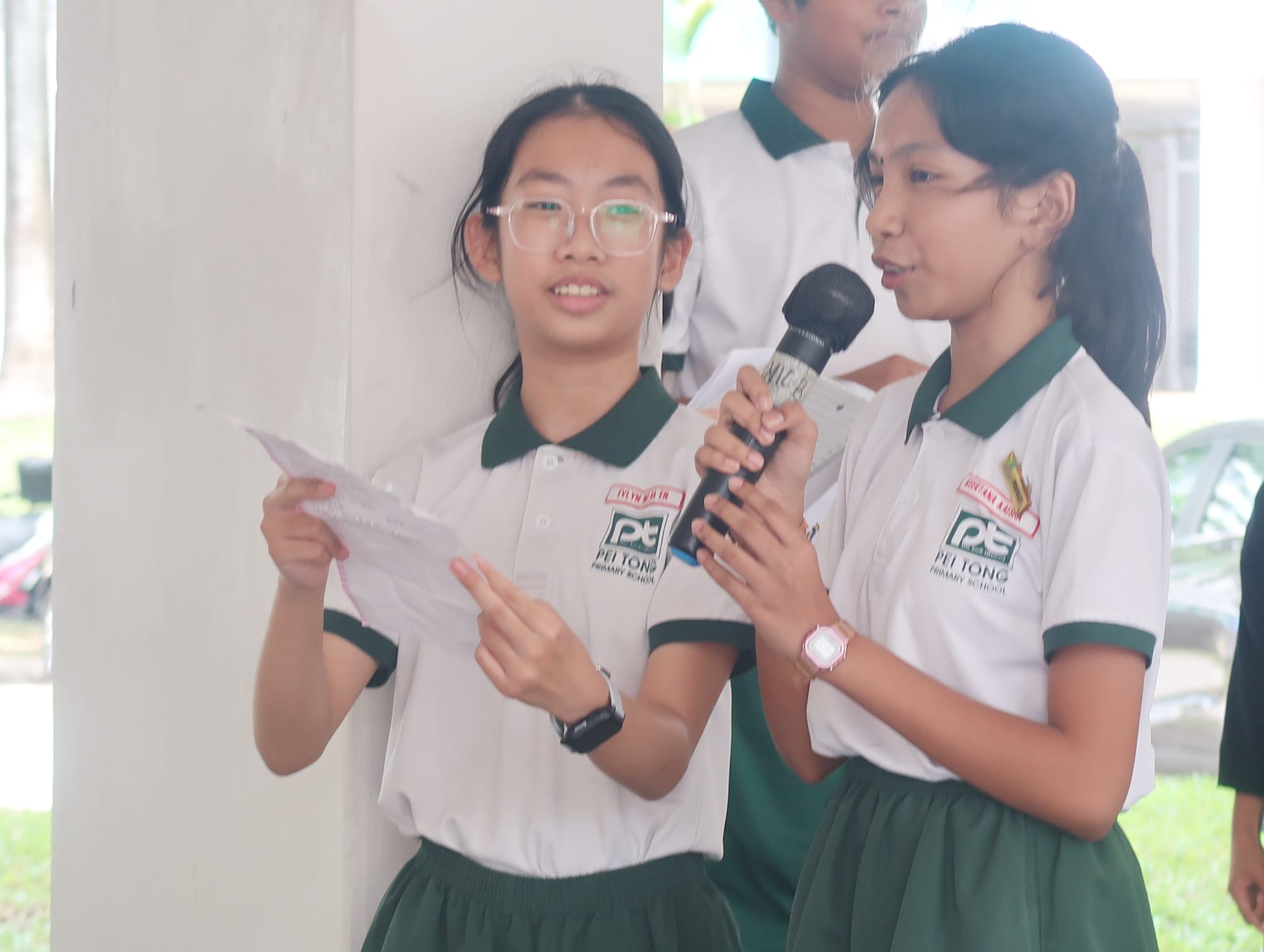 Students take turns speaking into a microphone as they host and present activities for seniors during a community engagement programme.