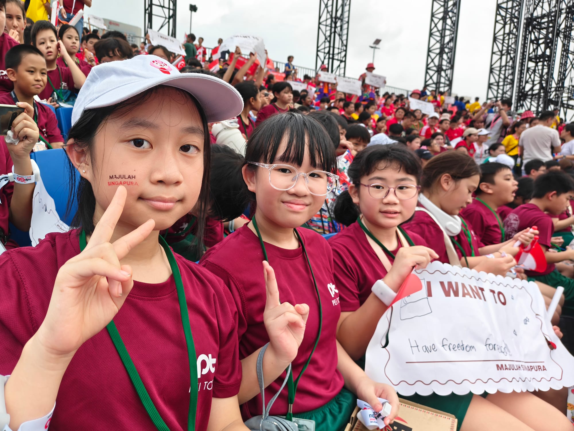 Primary 5 students pose with Singapore flags and National Education materials while enjoying the National Education Show.