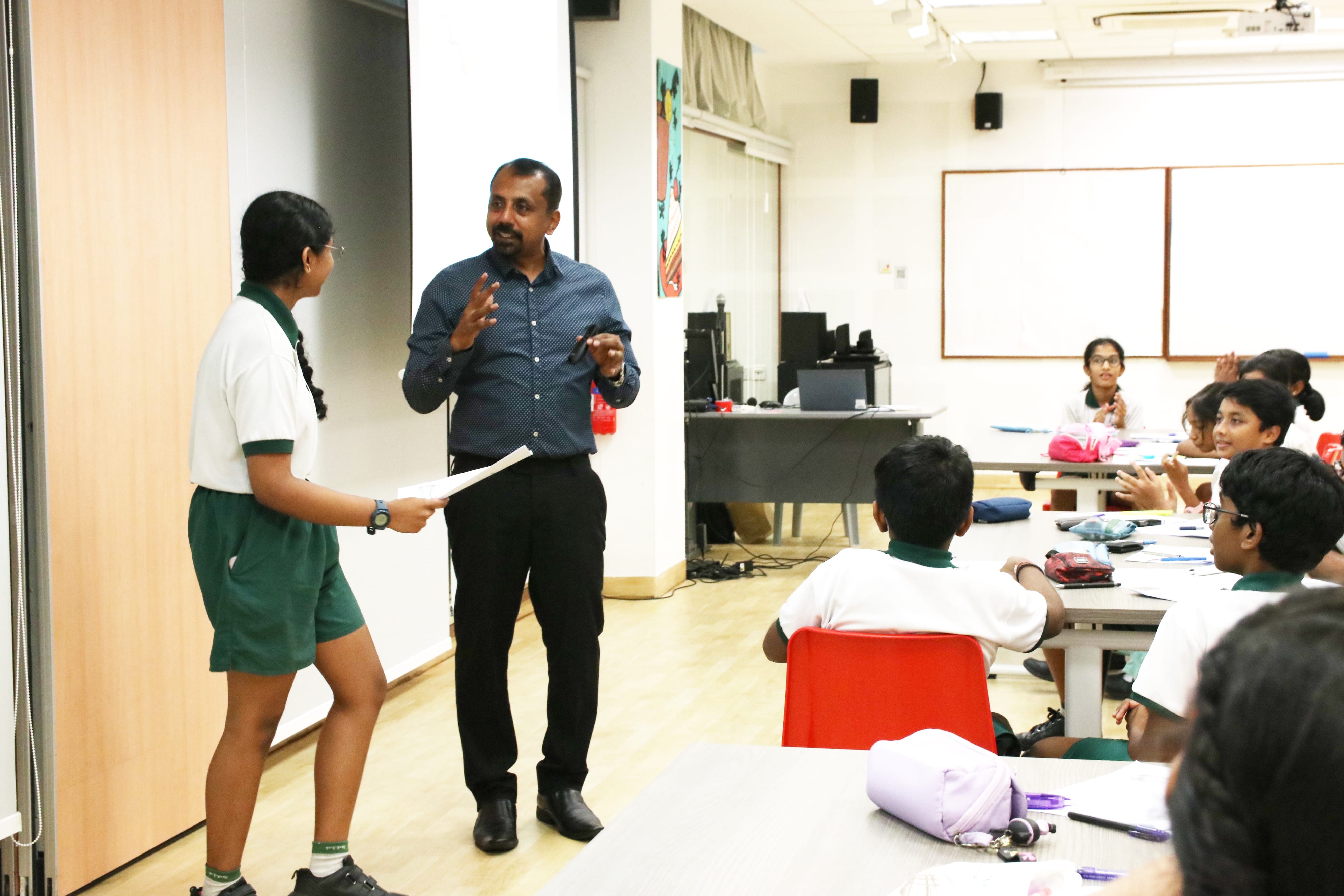 Student presenting her creative writing piece to classmates during a writing workshop, building confidence in sharing her ideas and creativity.