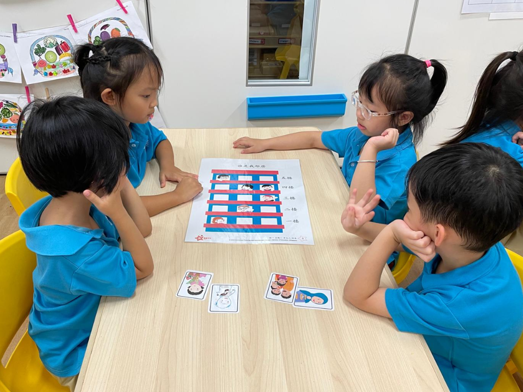 Children discuss a picture-based story activity in small groups, building communication, comprehension and critical thinking skills.