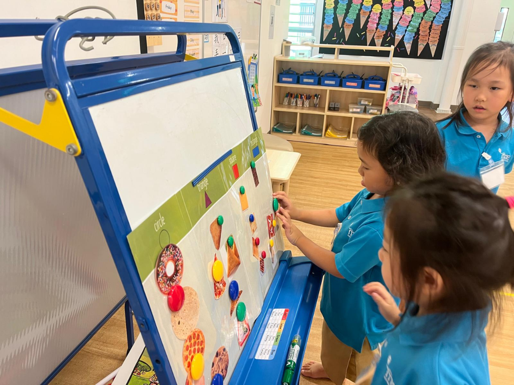 Children sort and match pictures by shape and colour using a magnetic board, strengthening vocabulary, observation and classification skills.