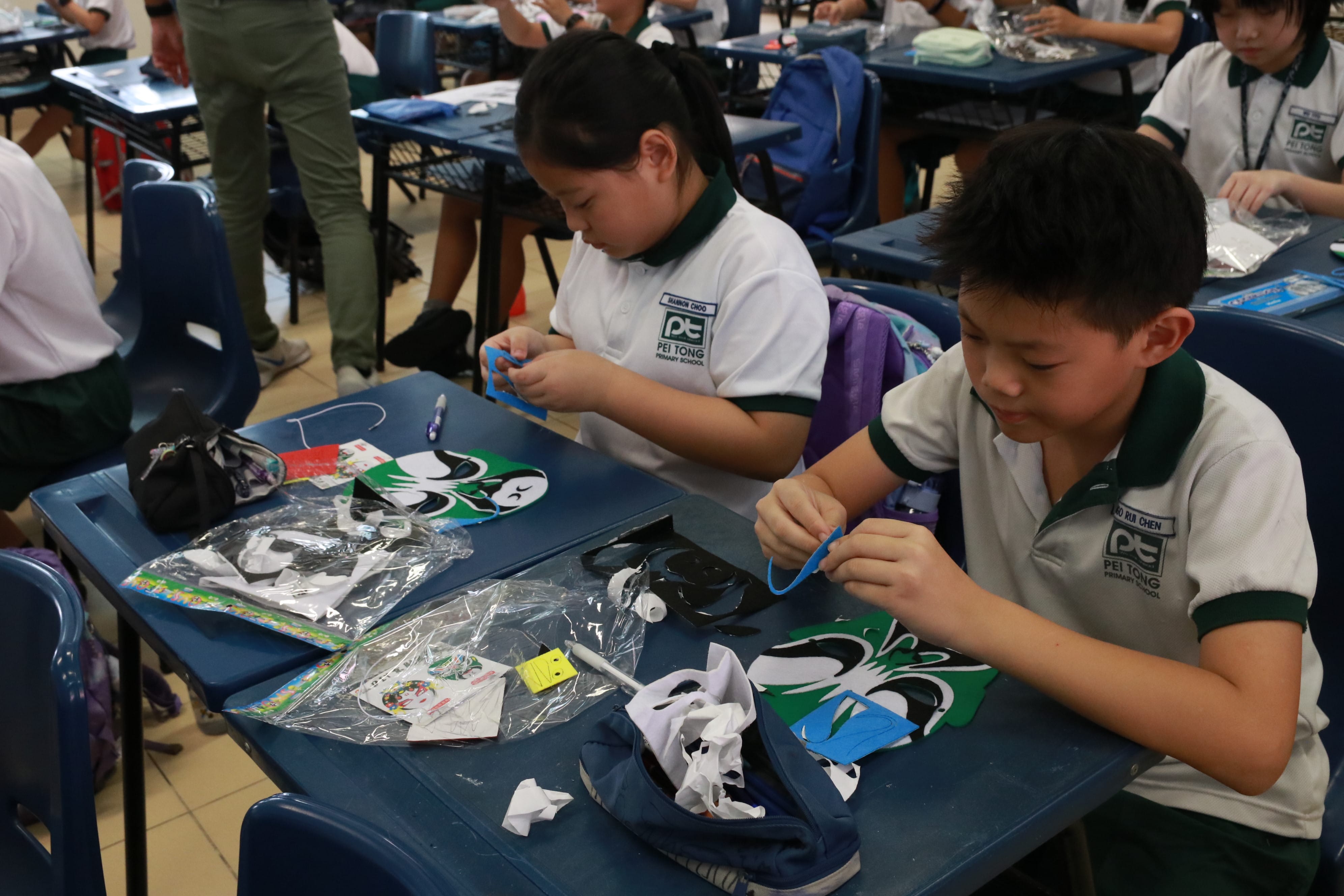 Students focused on assembling and decorating traditional opera masks