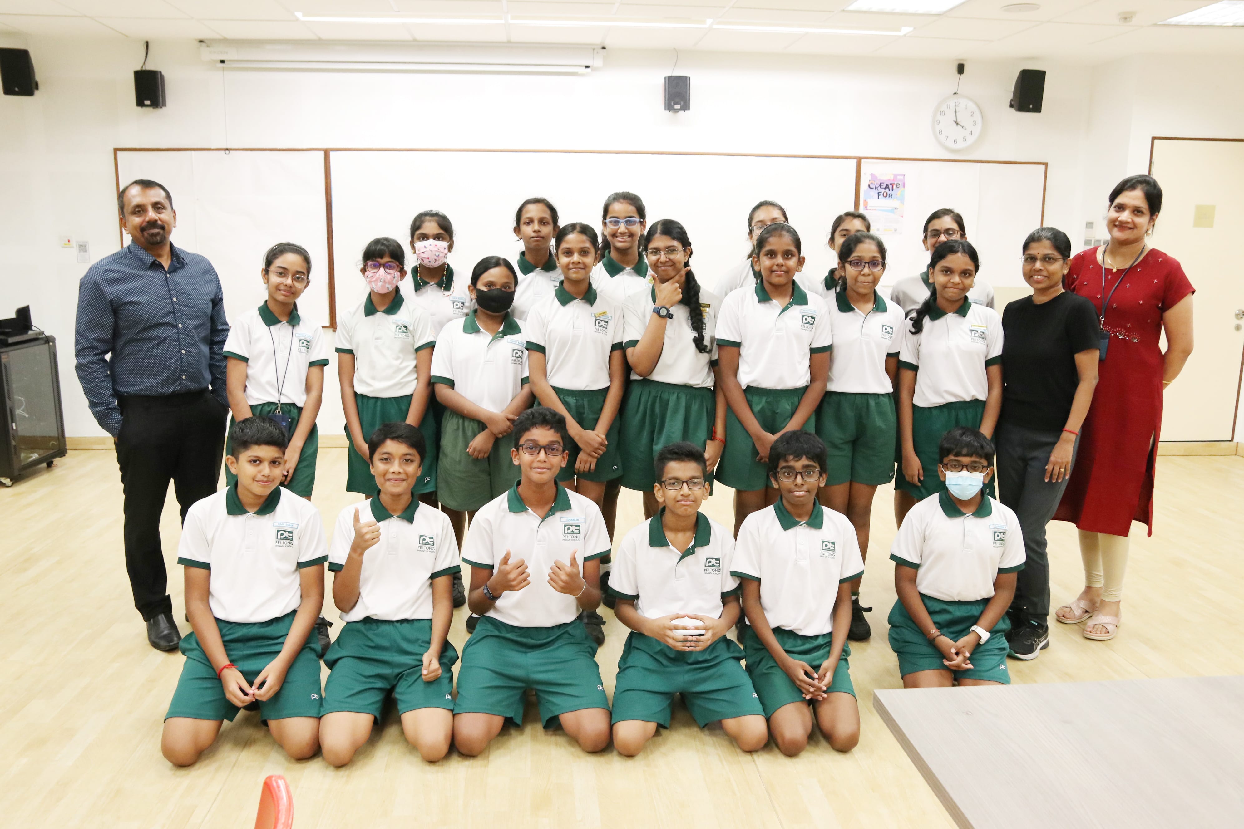 Primary 5 and 6 students posing with the workshop facilitator after a creative writing session, celebrating their learning and writing achievements.