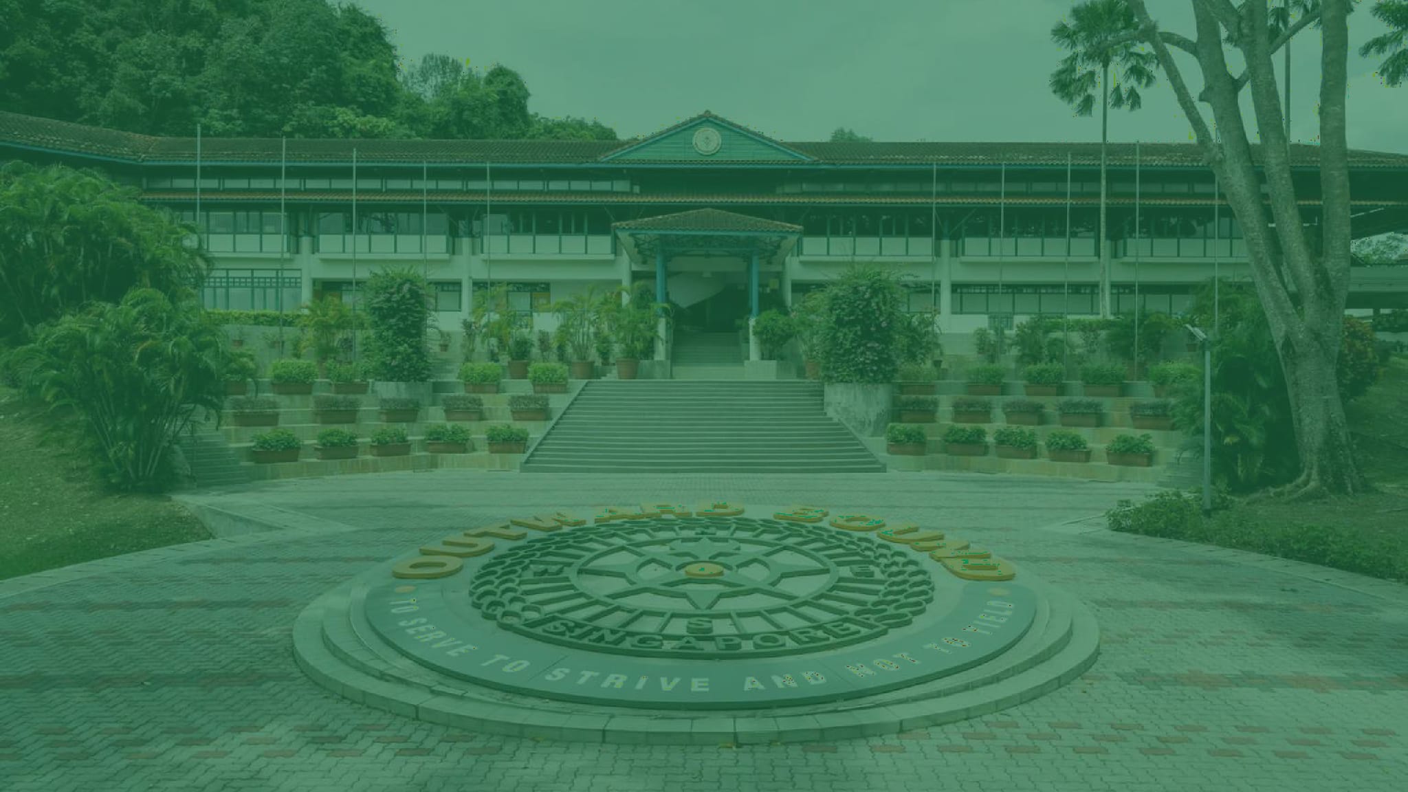 Outward Bound Singapore building with a circular emblem on the courtyard reading "To Strive And Not To Yield."