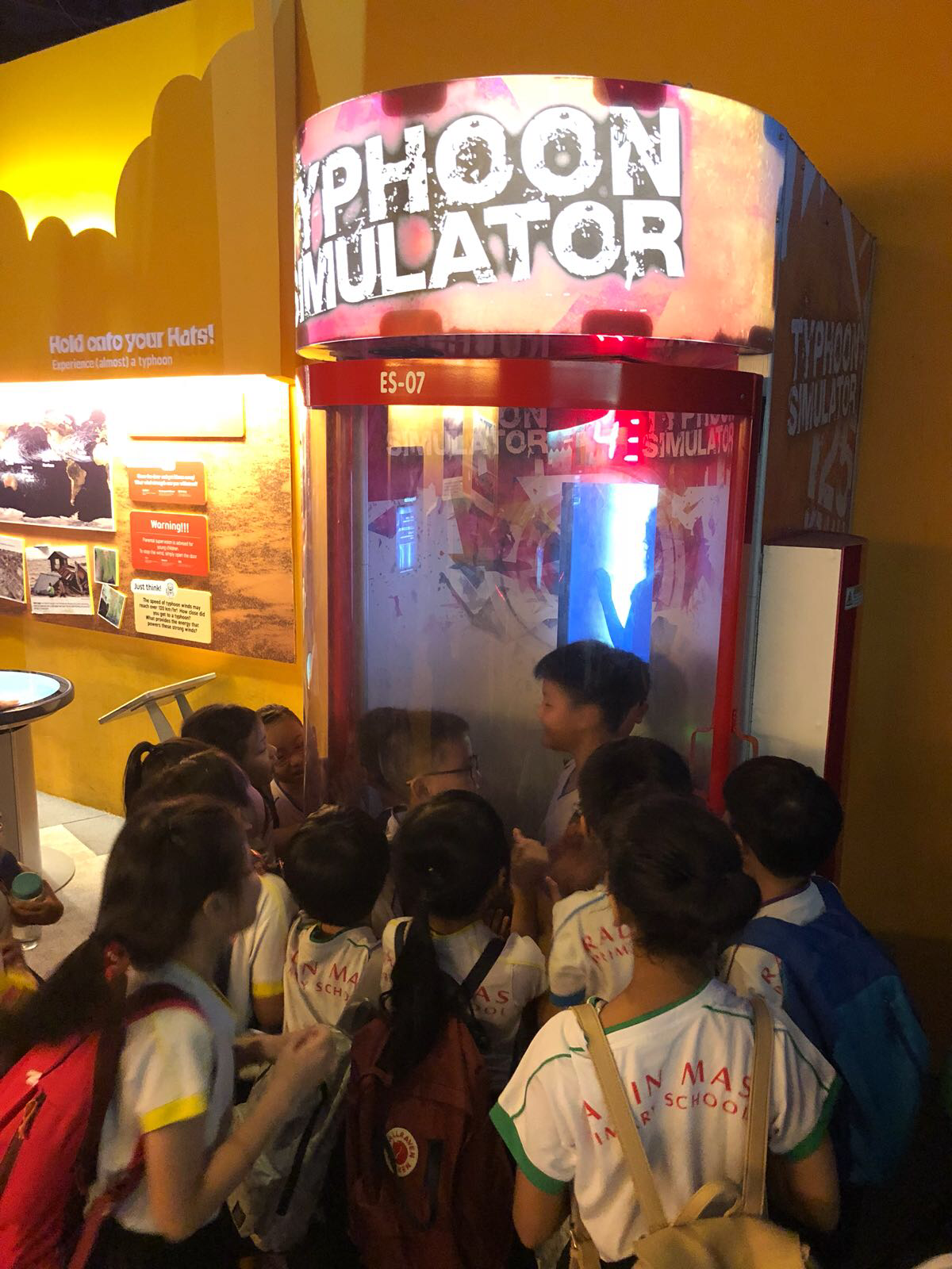 students trying typhoon simulator during learning journey