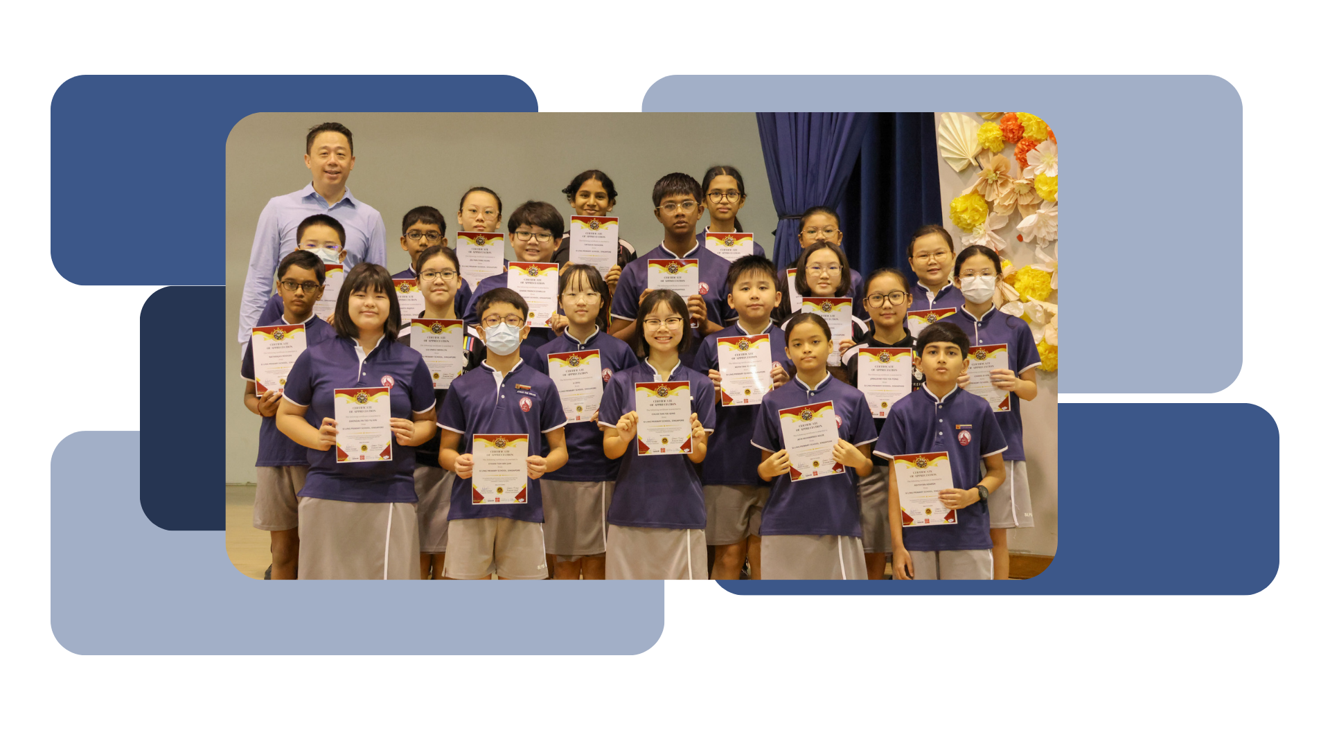 Group of students in purple uniforms holding certificates, posing with an adult man in a school hall.