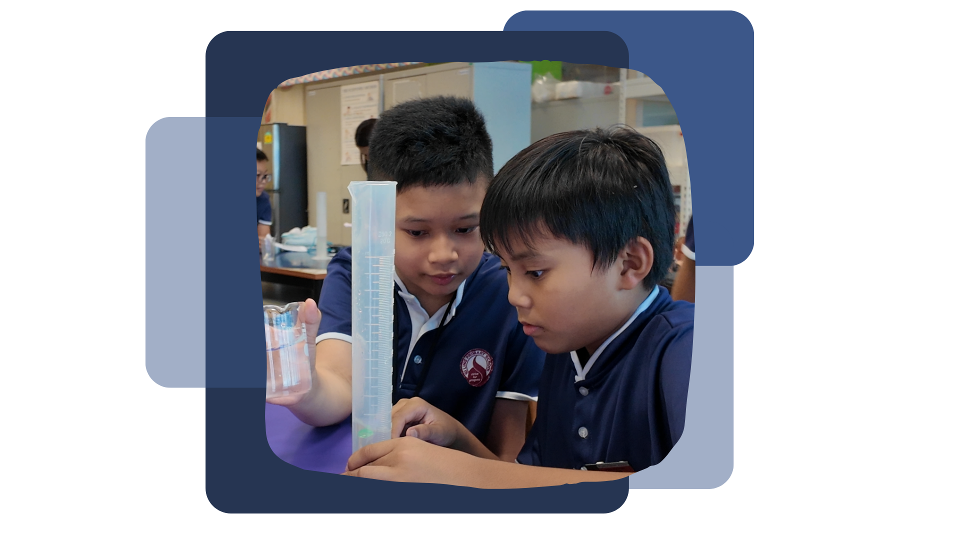 Two young students in navy uniforms examine a graduated cylinder and beaker during a classroom science experiment.