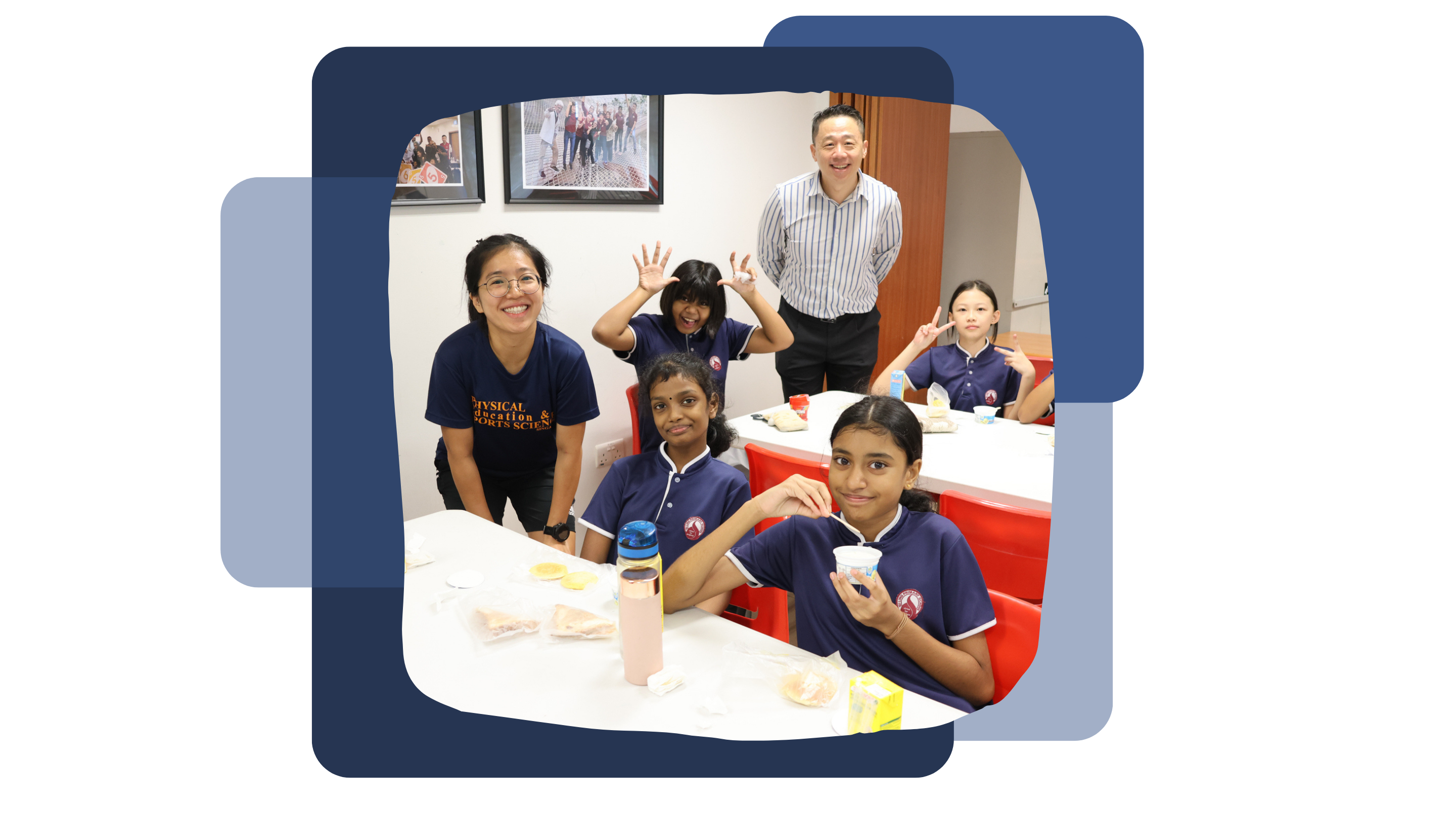 Our principal, Mr Koe, together with Ms Janice Tan, and 4 female students smiling and pose around a white table with food items.