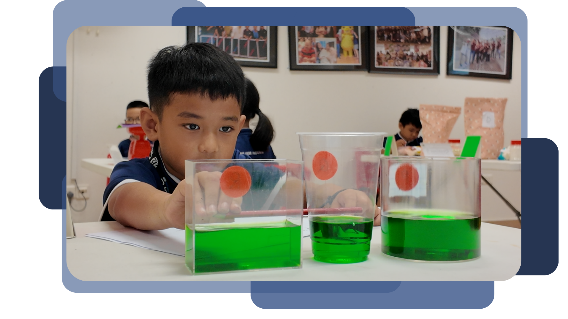 A student peers closely at three containers of different shapes filled with green-coloured water, each marked with a red dot, during a hands-on mathematics activity exploring volume and capacity.