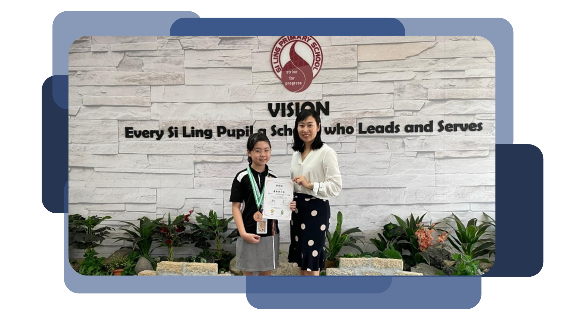 A student with a medal and an adult hold a certificate in front of Si Ling Primary School's vision wall.